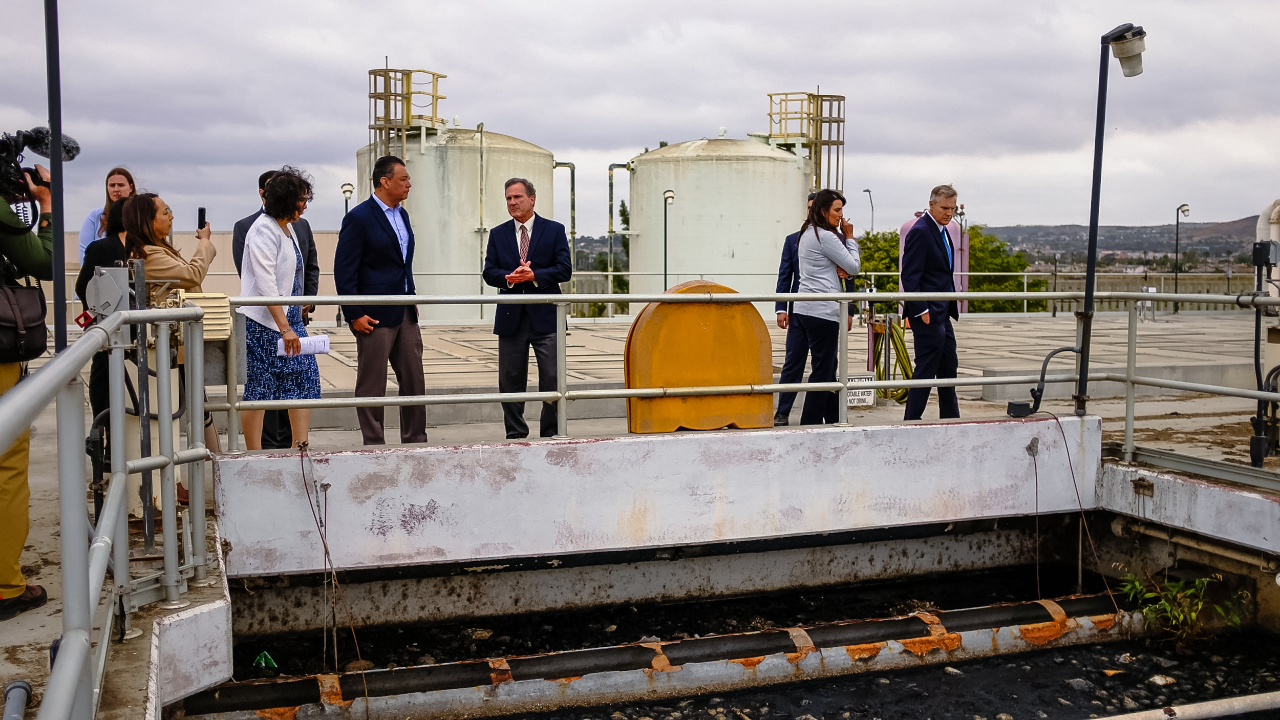 California Sen. Alex Padilla talks with South Bay International Wastewater Treatment Plant Area Operations Manager Morgan Rogers on June 5, 2023. The two overlook the overloaded primary treatment system.