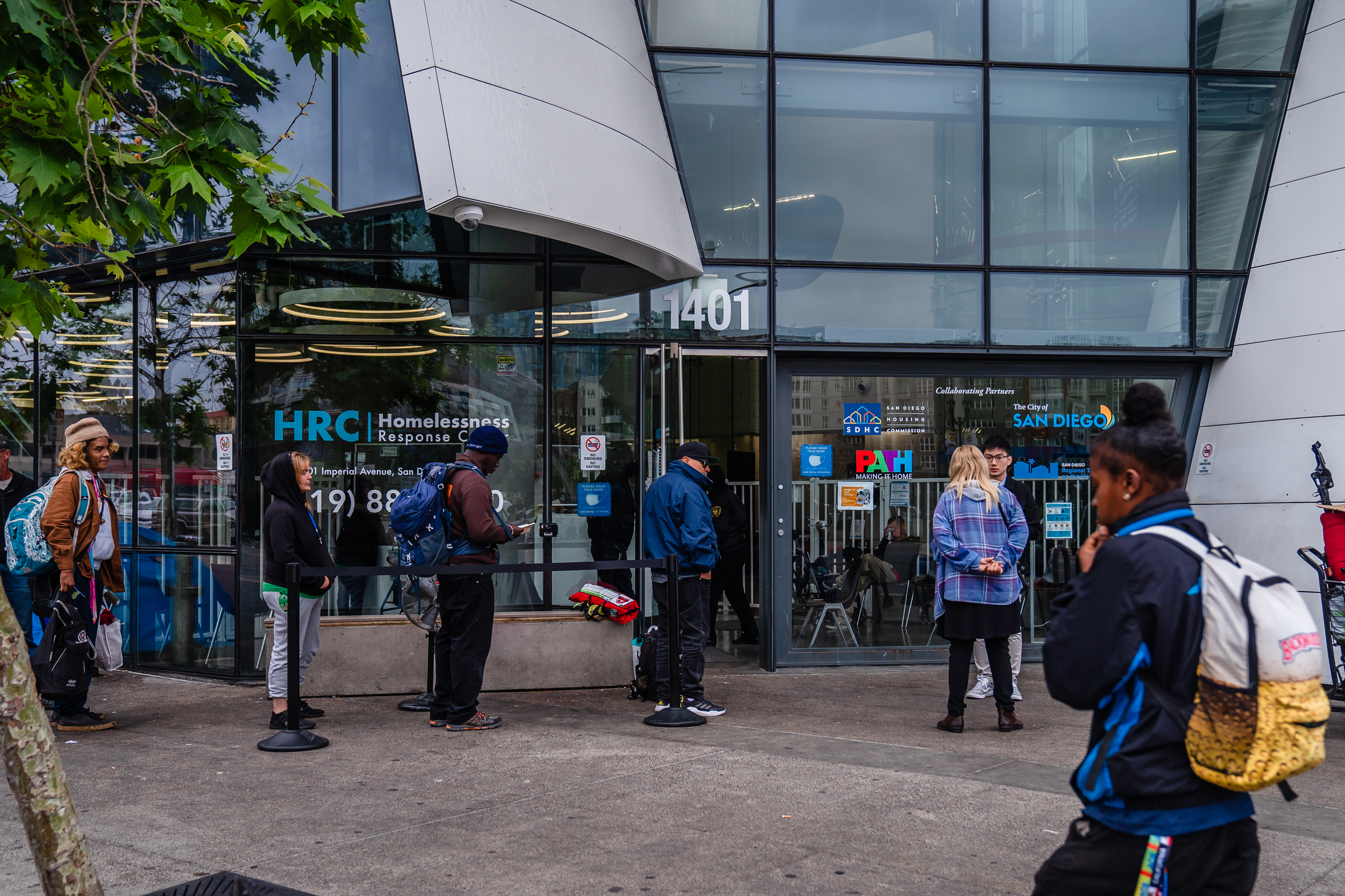 People that are unhoused stand in line early morning outside of the Homelessness Response Center in the East Village waiting to see if they will be able to stay in shelter on June 5, 2023.