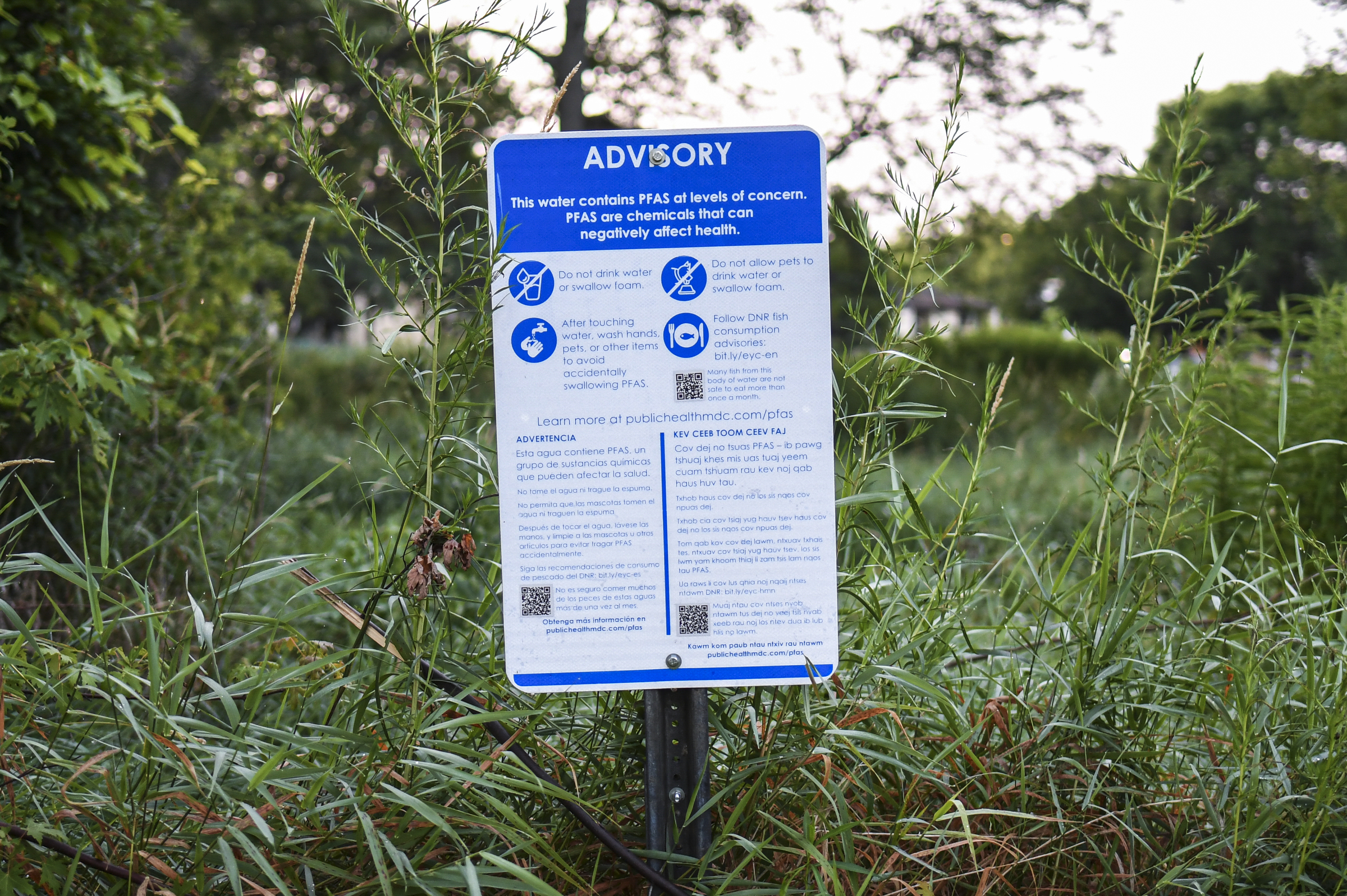Advisory sign in front of greenery