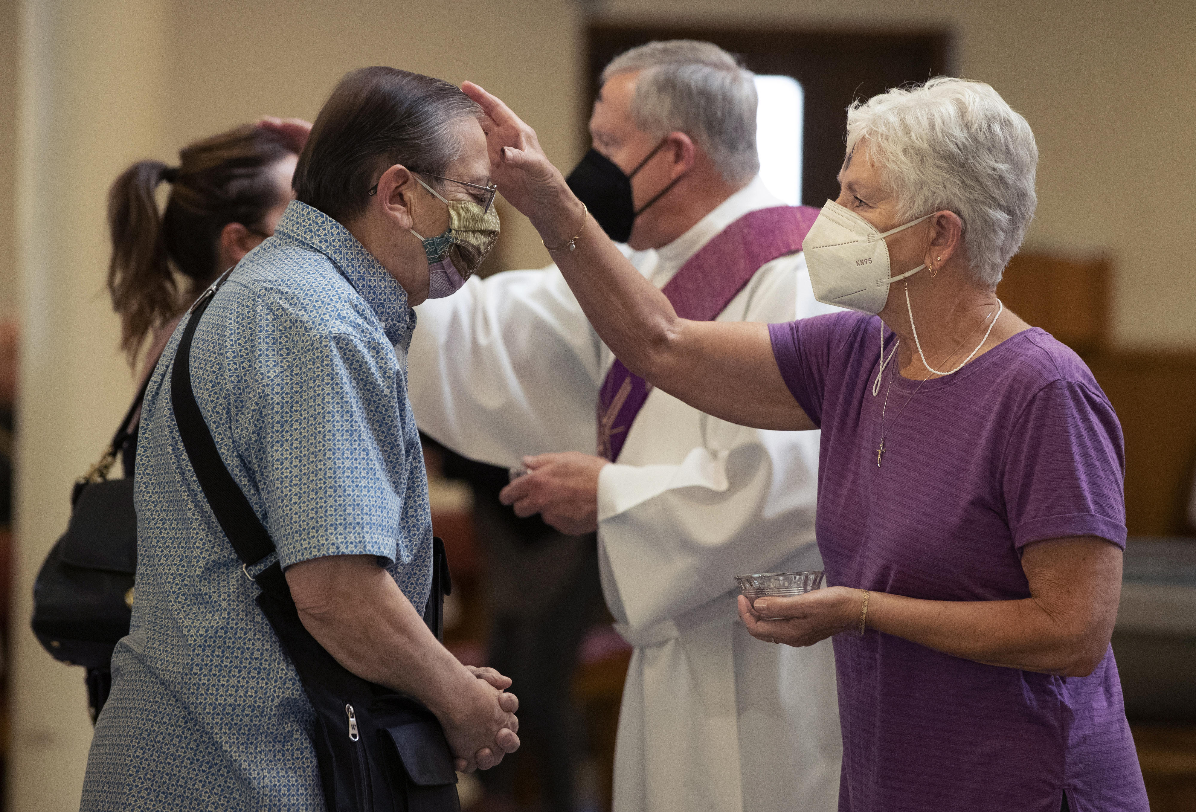 Minister Sue Rubick, right, and Deacon Mike Freeman, second from right, administer ashes to parishioners during an Ash Wednesday ceremony at St. Bruno Catholic Church in Whittier, on Wednesday, March 2, 2022. (Photo: Alex Gallardo/Contributing photographer)