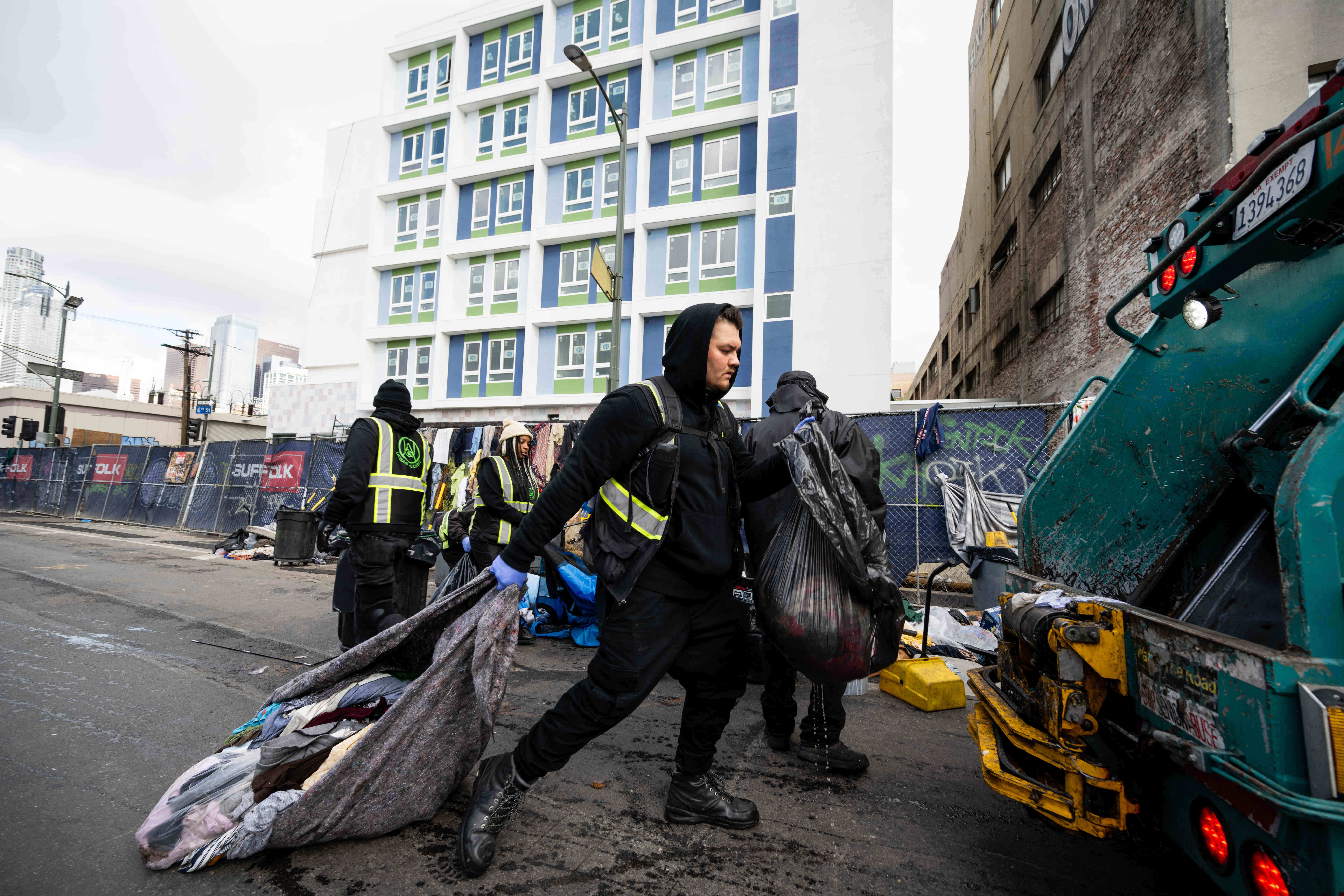 Urban Alchemy and the sanitation department clean up the street across from the Midnight Mission in Los Angeles' skid row on Monday, December 12, 2022.