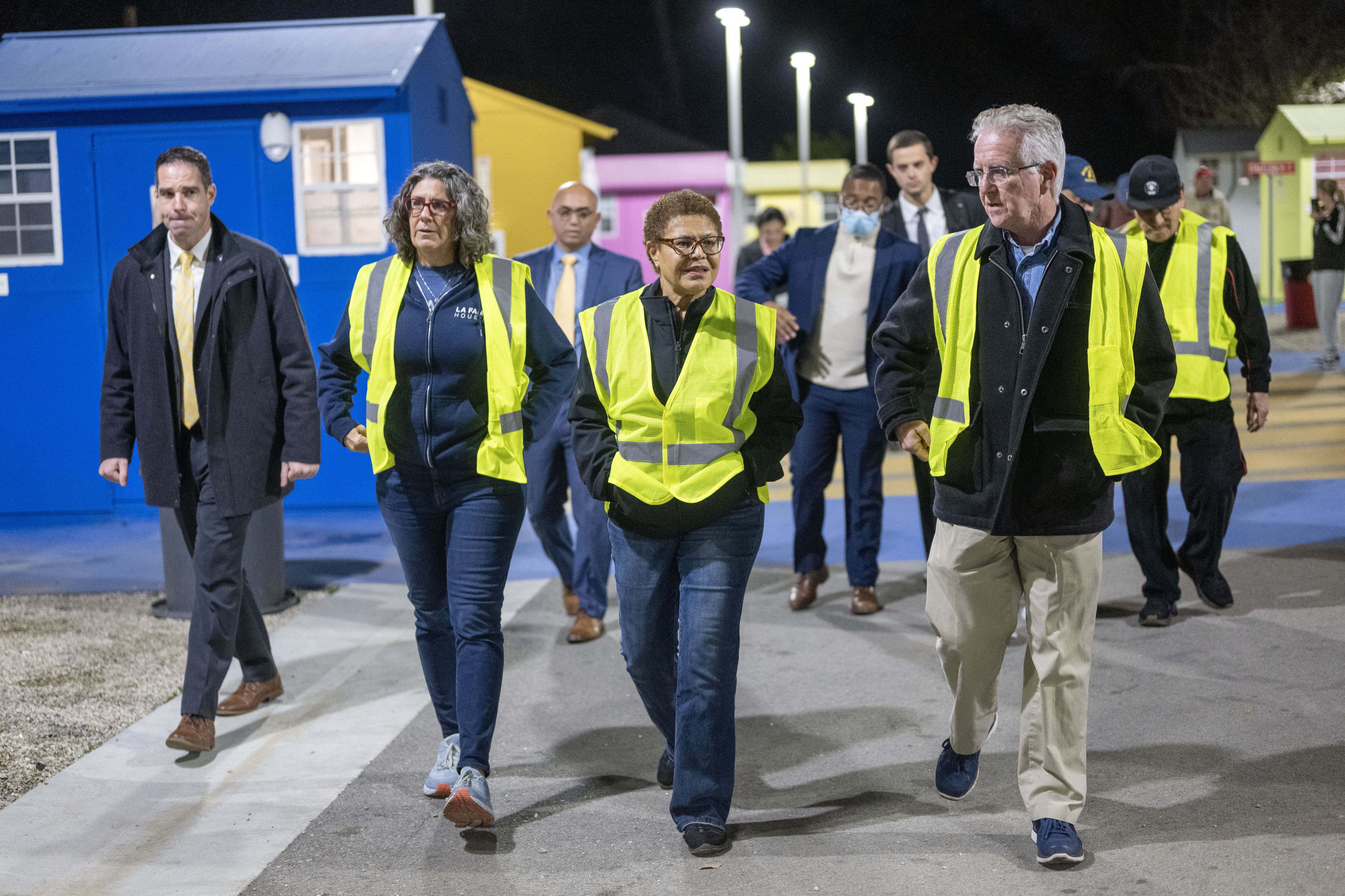 Stephanie Klasky-Gamer, president and CEO of LA Family Housing, Karen Bass, mayor of Los Angeles, and Paul Krekorian, Los Angeles City Council president, make their way through Alexandria Park Tiny Home Village in North Hollywood, Calif., during the first night of the 2023 Greater Los Angeles Homeless Count, Tuesday, Jan 24, 2023. 