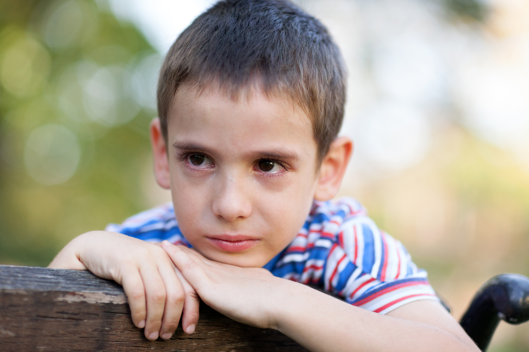 A ADHD young boy with anxiety crying outdoors