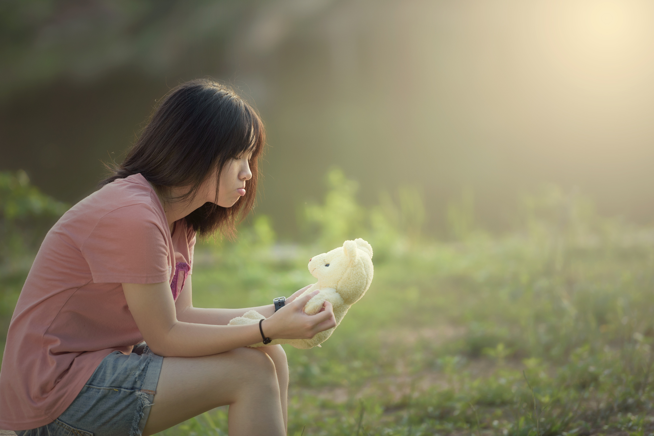 A young girl with anxiety, sitting in a field