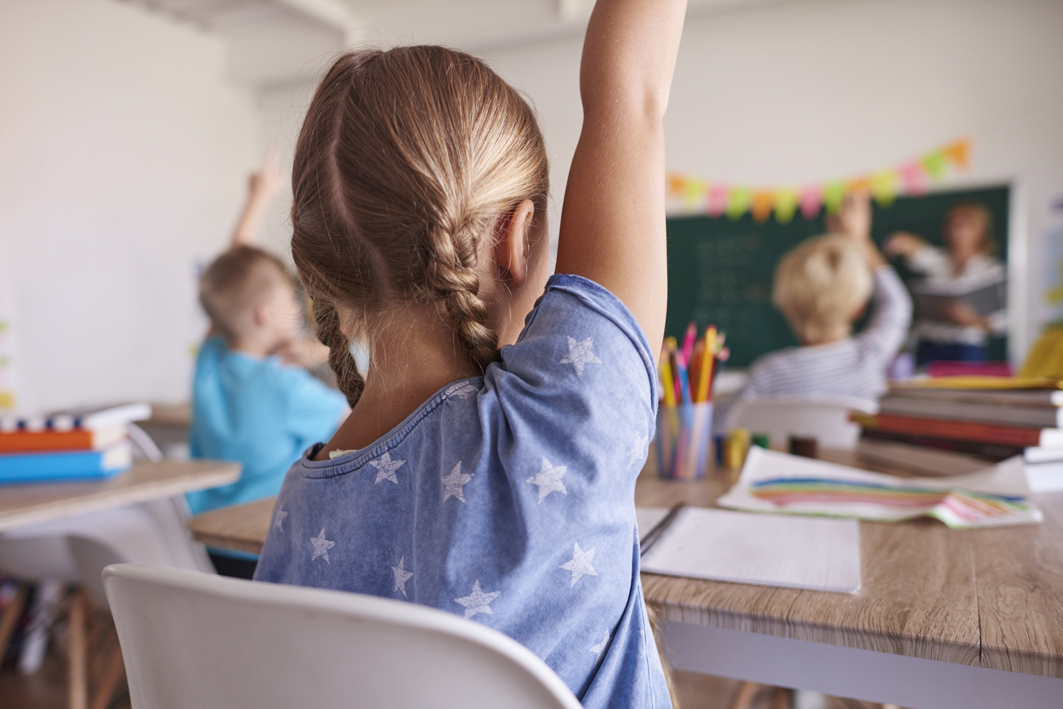 School children with ADHD raising their hands in class