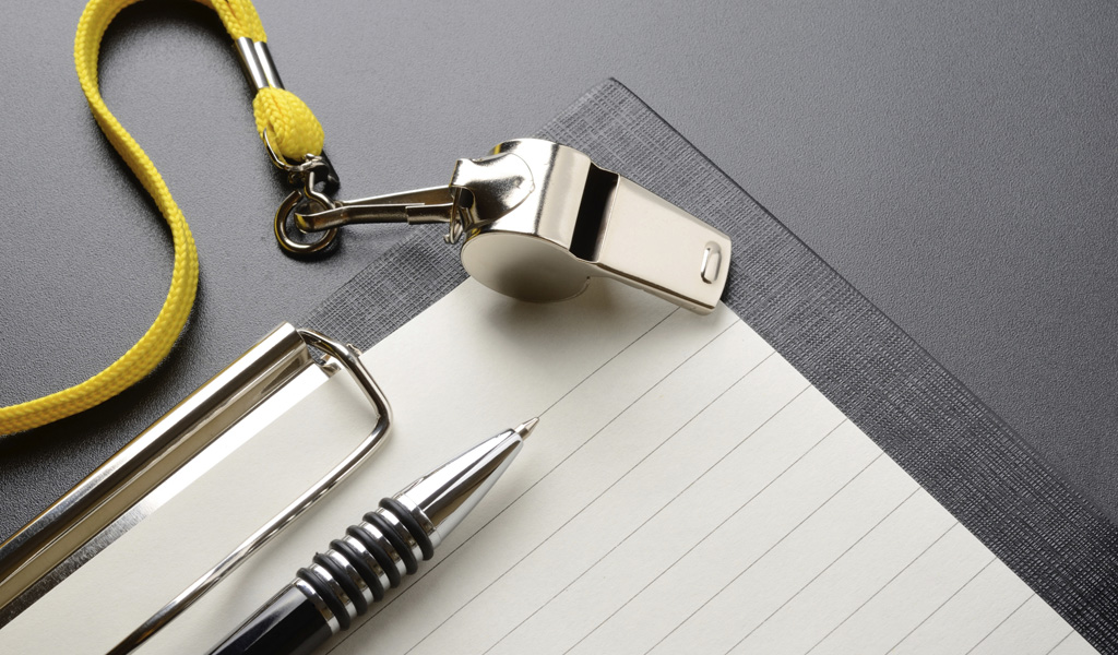 A pen and paper next to a whistle that might be used by an ADHD life coach