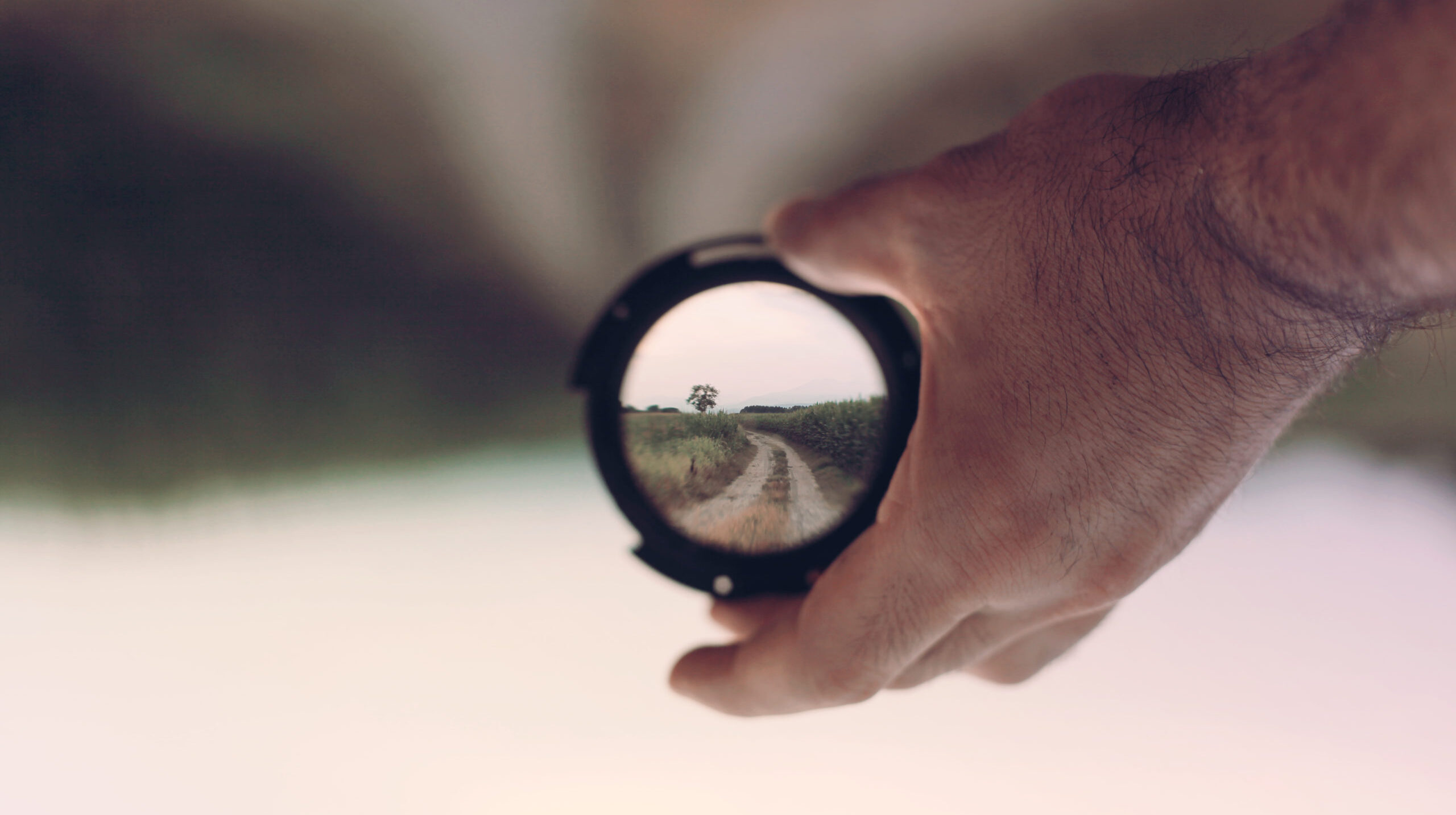 Hyperfocus: Man with ADHD holding lens with focused image of landscape inside it