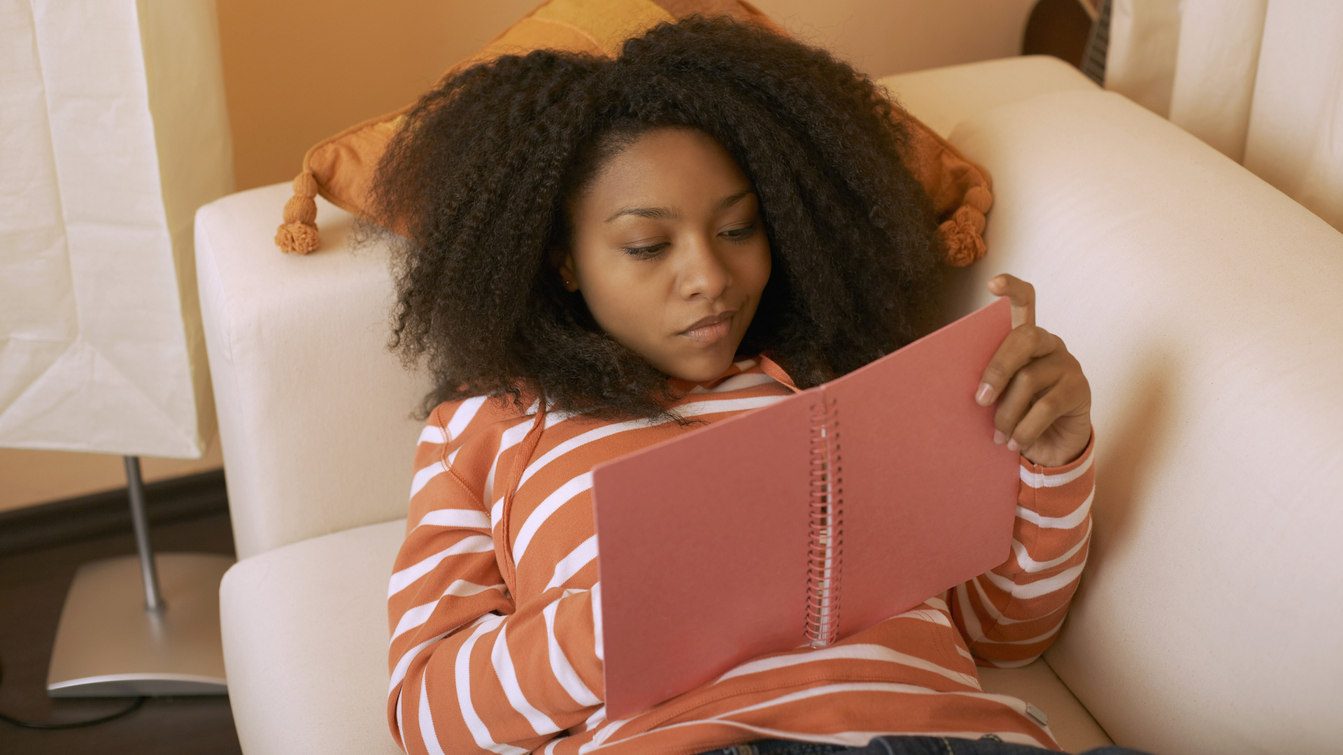 A high school girl writing in a pink planner