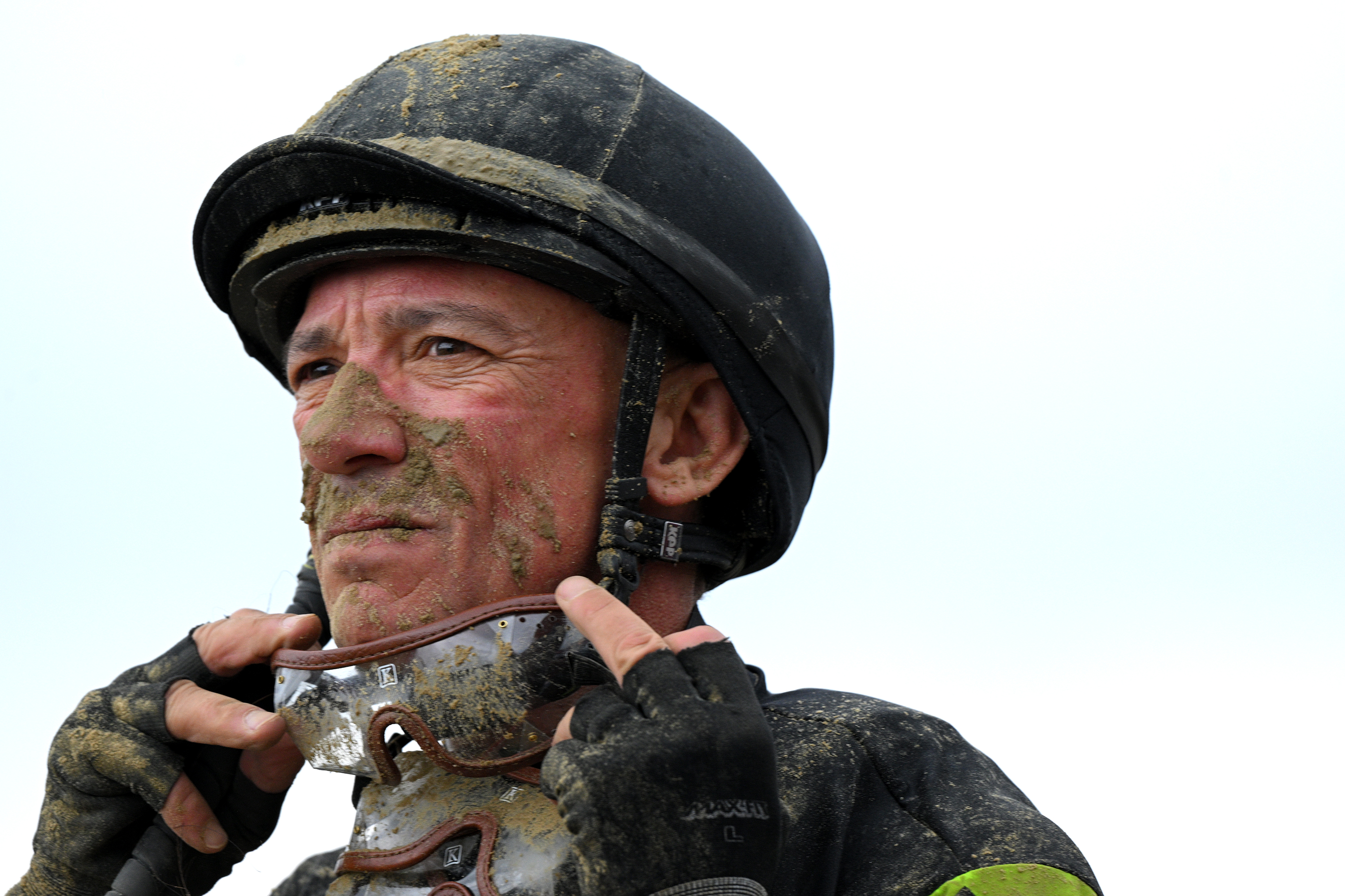 Lanfranco Dettori removes his racing goggles after finishing the 4th race riding Royal Poppy at Pimlico. The 2024 Preakness at Pimlico Race Course Saturday. (Lloyd Fox/Staff)