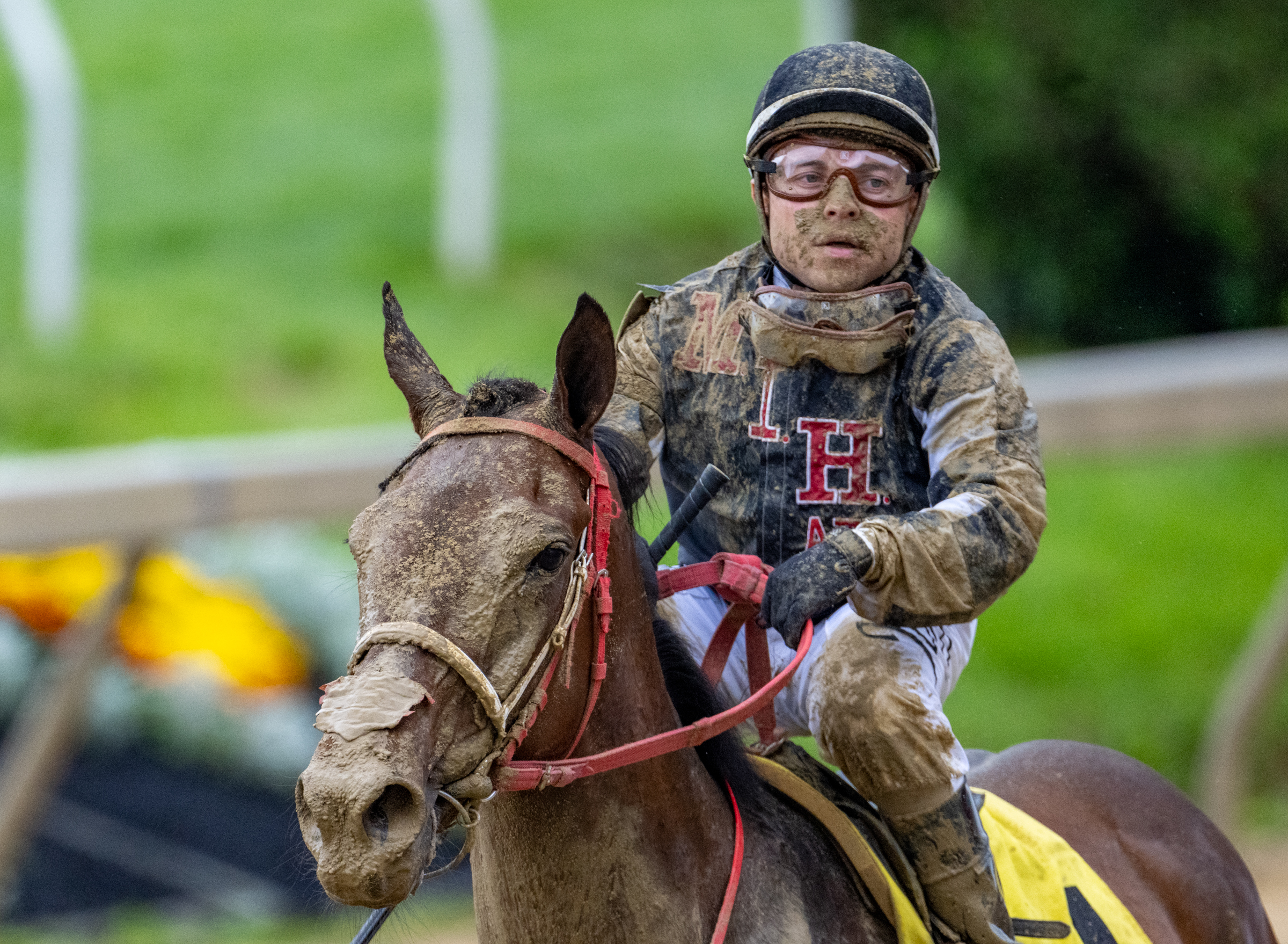 A muddy Jorge Hernandez rides Open the Books after trailing much of the All May Arcoleo Memorial Race, the third race of the day on Preakness Saturday. (Jerry Jackson/Staff)