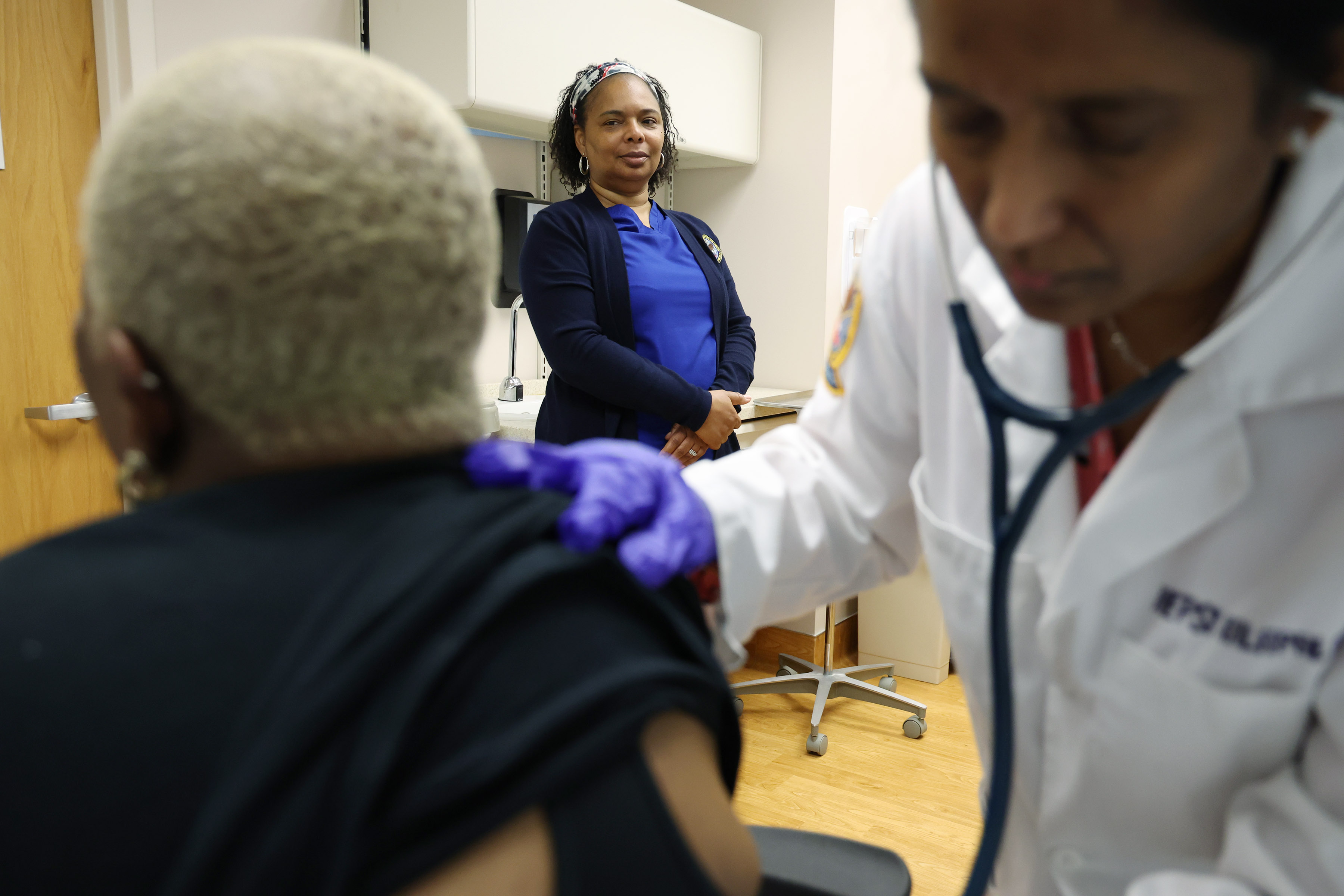 Cheryl Stevenson, center, a licensed practical nurse and chaperone, watches as Dr. Hepsi Kalapala, right, examines Quying Holmes at Edward Hines Jr. VA Hospital in October. (Stacey Wescott/Chicago Tribune)