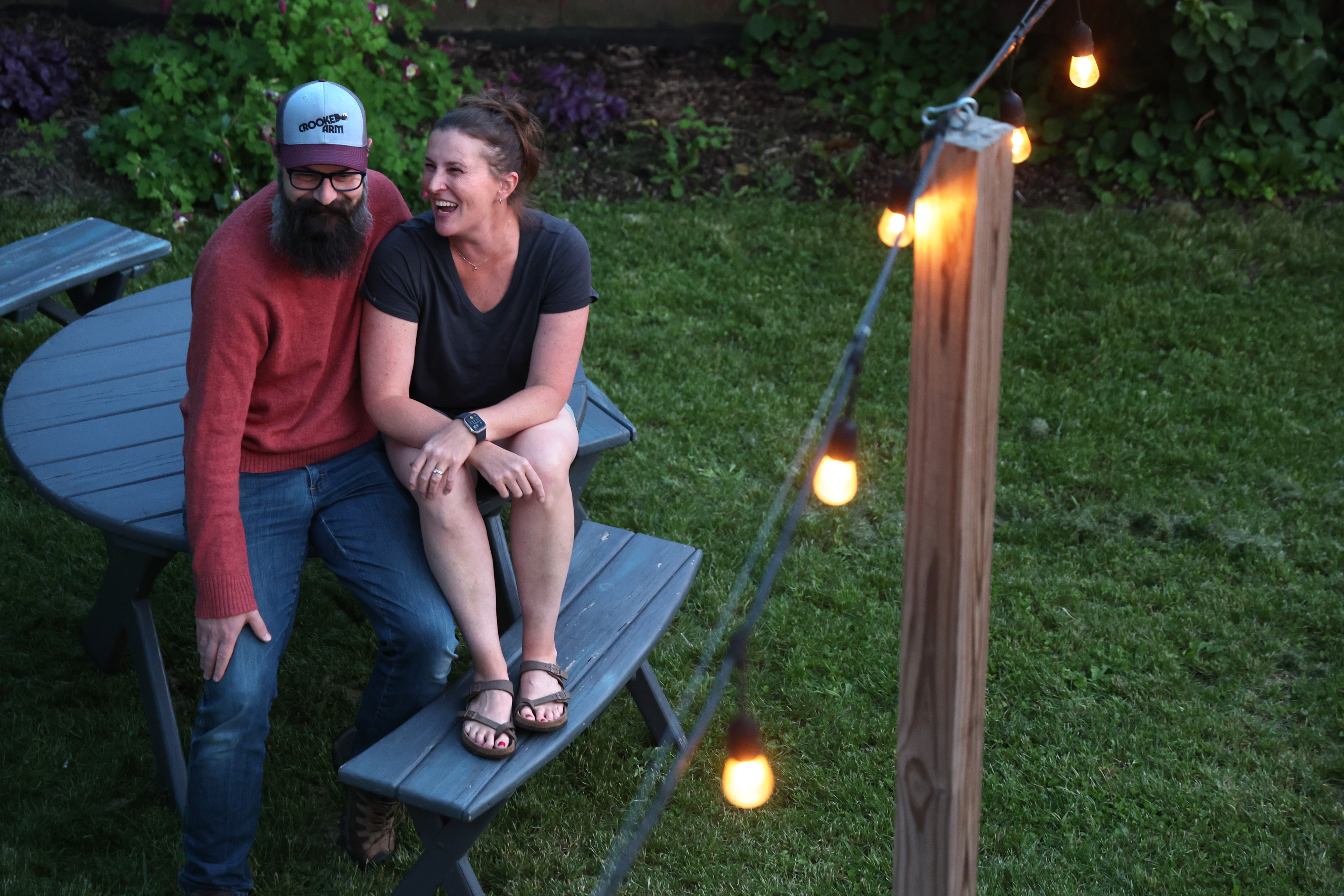 Sasha and Jason Darby, owners of Mapleton Barn, sit on a picnic table at the end of the evening following their Pizza Farm event on May 30, 2024, in Oconomowoc, Wisconsin. This is their sixth year teaming up with food vendor Flour Girl & Flame. Mapleton Barn provides the farm setting and Flour Girl & Flame bake the pizzas. (Stacey Wescott/Chicago Tribune)