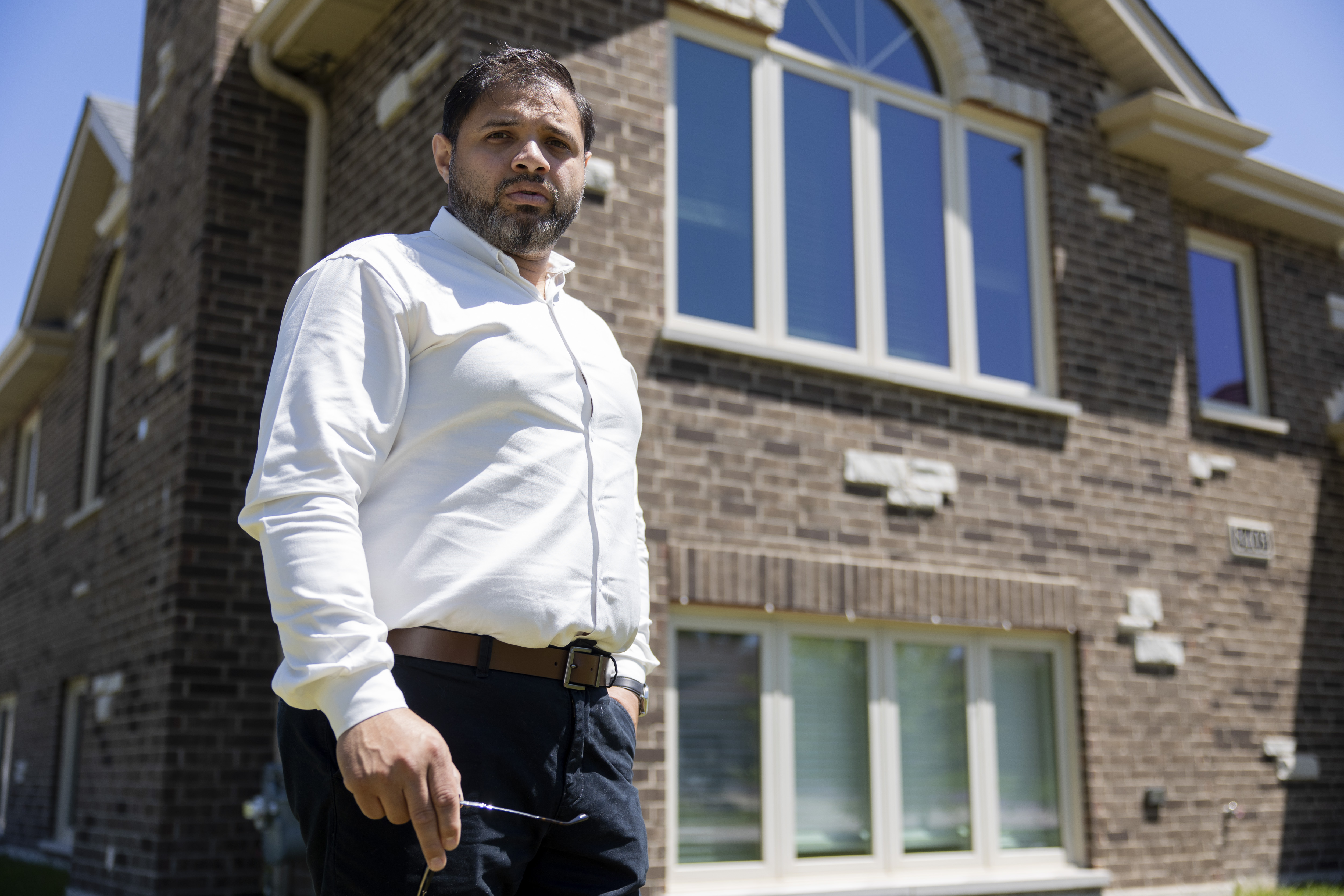 Naveed Anwer stands outside his home on May 30, 2024, in Justice, Illinois. Anwer is a first time homeowner who received a large back-tax bill because permits for the home were not properly submitted to the Assessor's office. (Vincent Alban/Chicago Tribune)