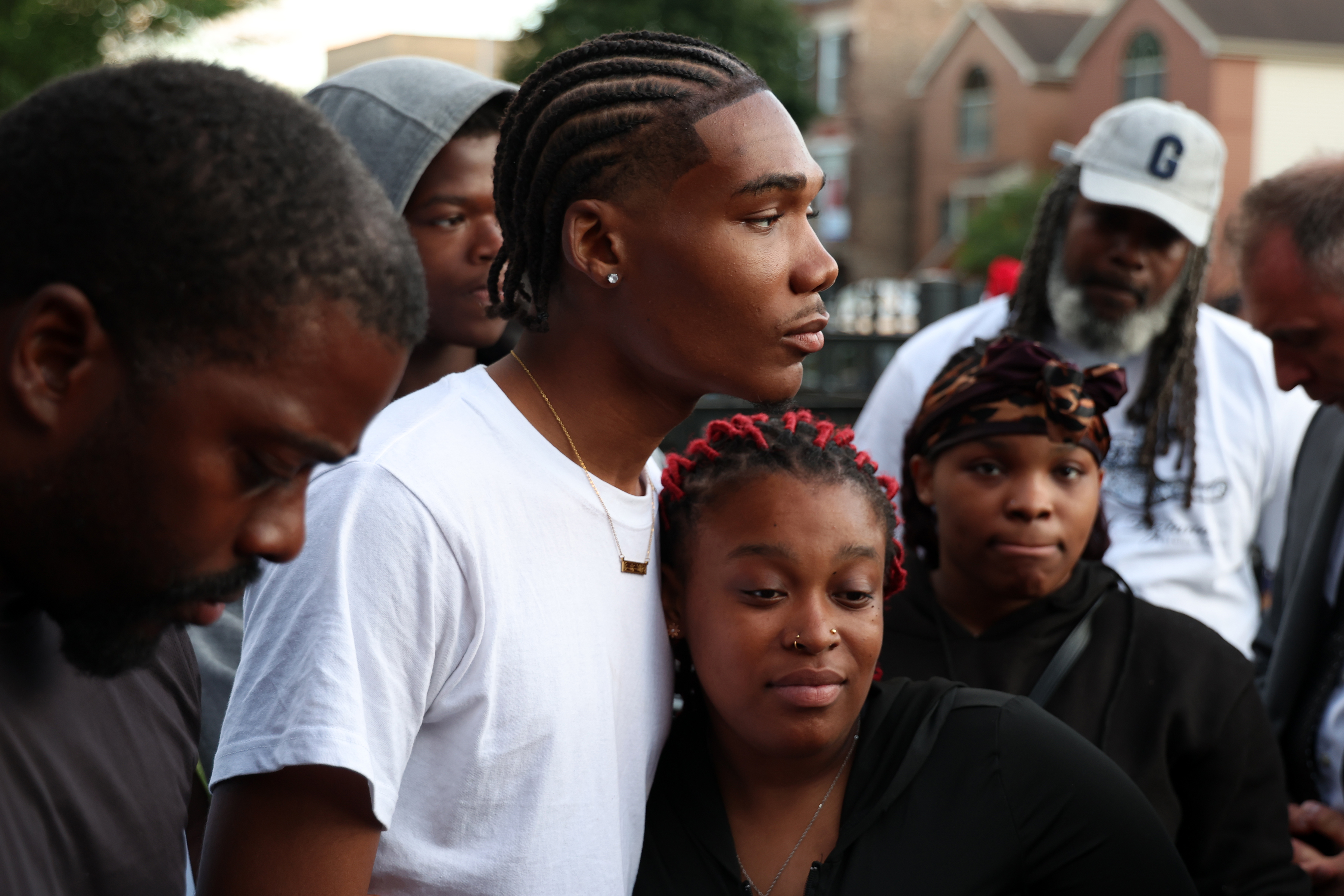 Frank Mixon, center left, and Zariah Windbush, center right, mourn the deaths of their loved ones in the 7100 block of S. Woodlawn Avenue in Chicago on Friday, July 5, 2024. A mass shooting a day earlier left at least three people dead. (Terrence Antonio James/Chicago Tribune)