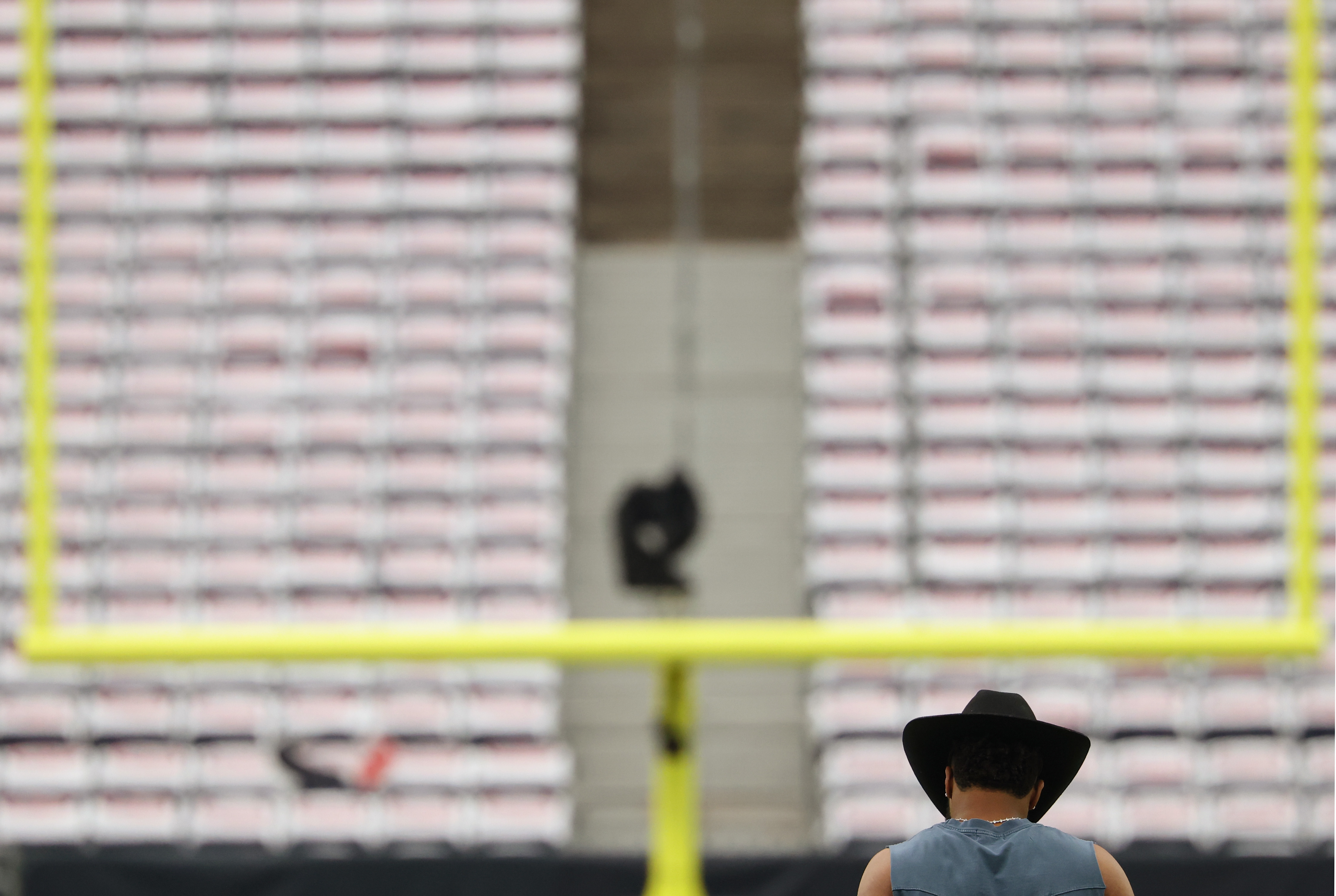 A worker wearing a cowboy hat walks on the field before a game between the Texans and Bears at NRG Stadium on Sept. 15, 2024, in Houston. (John J. Kim/Chicago Tribune)