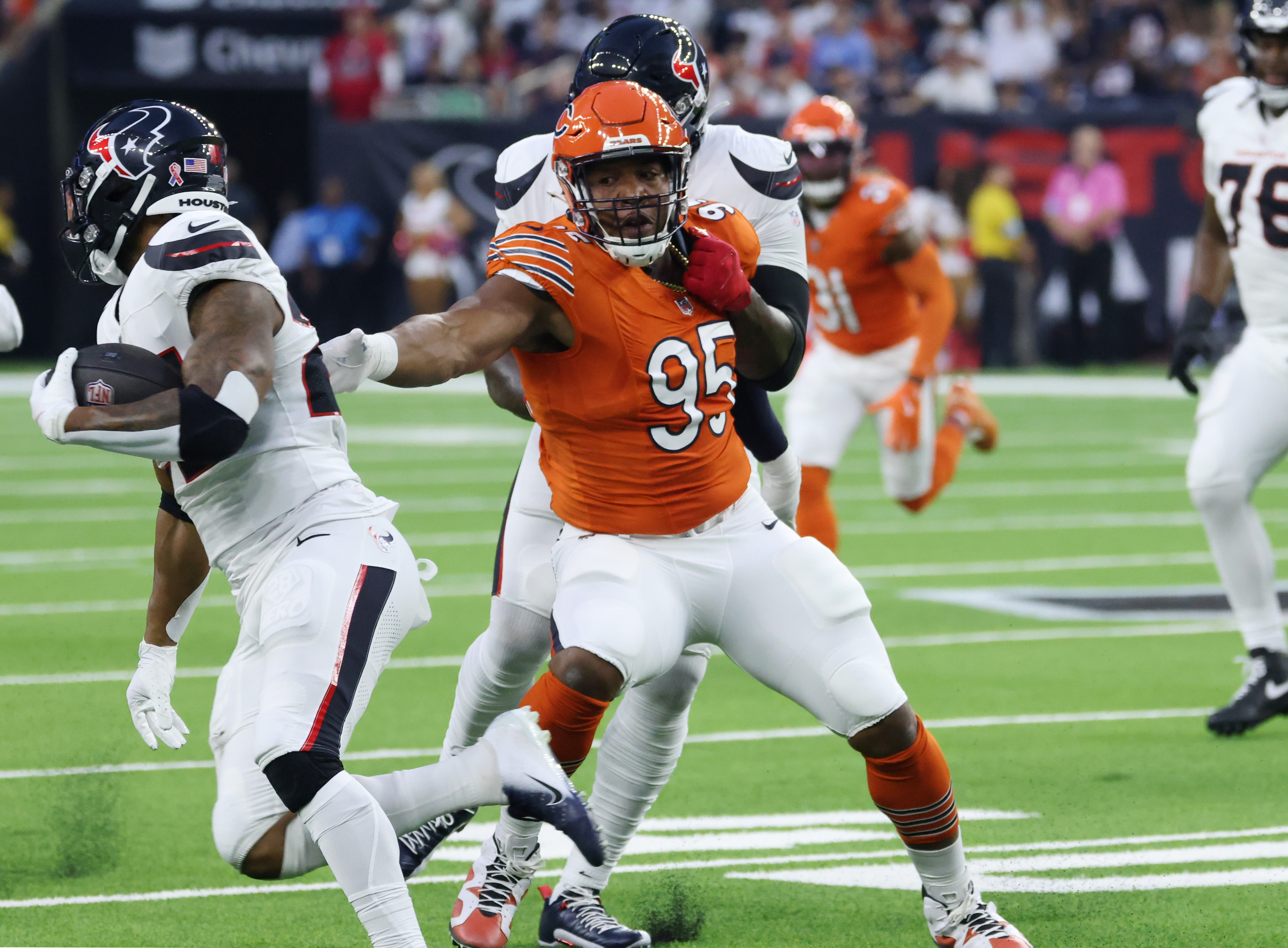 Bears defensive end DeMarcus Walker (95) is held by Texans offensive tackle Laremy Tunsil as Texans running back Joe Mixon (28) rushes in the first quarter at NRG Stadium on Sept. 15, 2024, in Houston. (John J. Kim/Chicago Tribune)