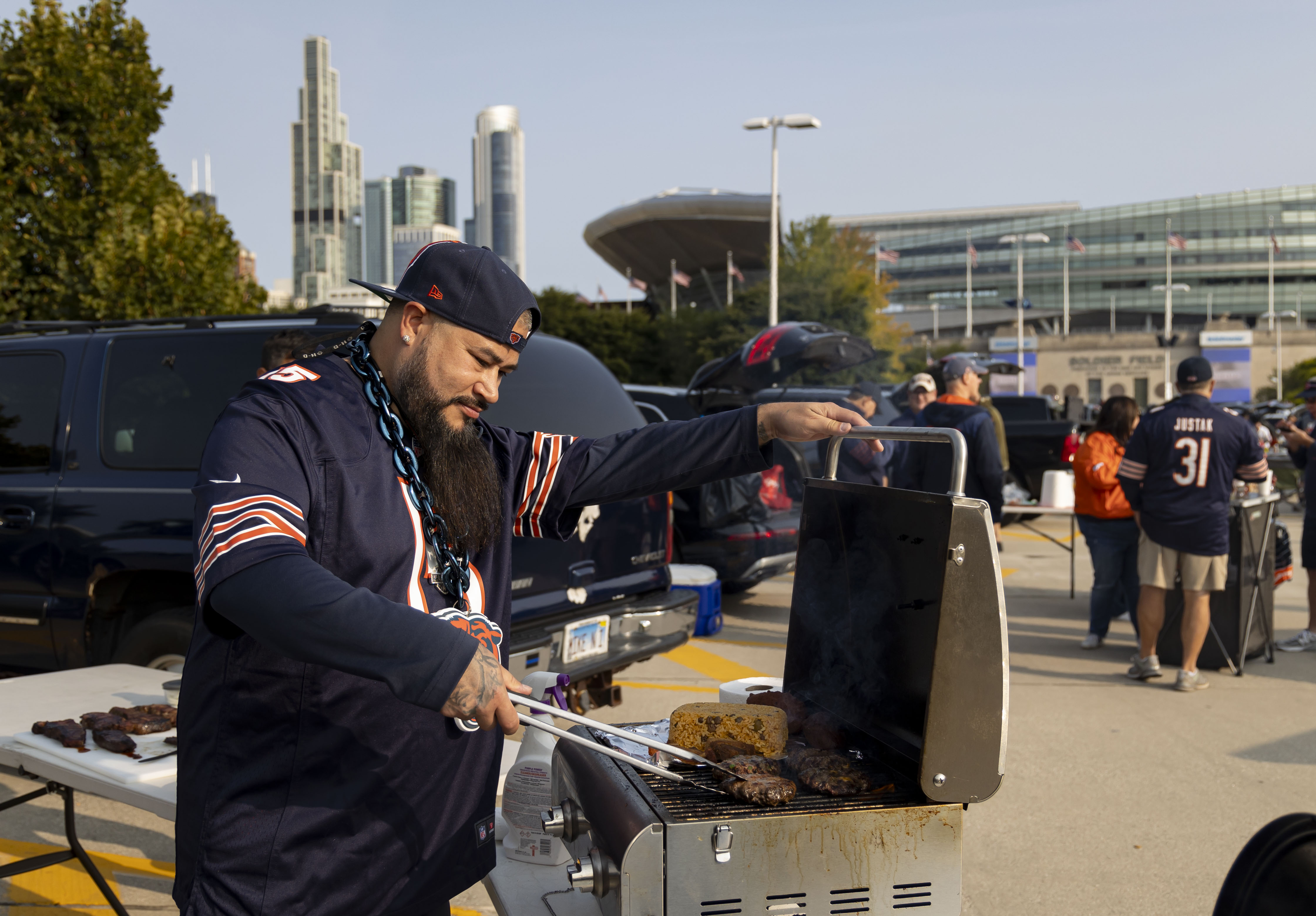 Mark Velez runs the grill while tailgating with other Chicago Bears fans before the face the Tennessee Titans in the season opener on Sunday, Sept. 8, 2024, at Soldier Field. (Brian Cassella/Chicago Tribune)