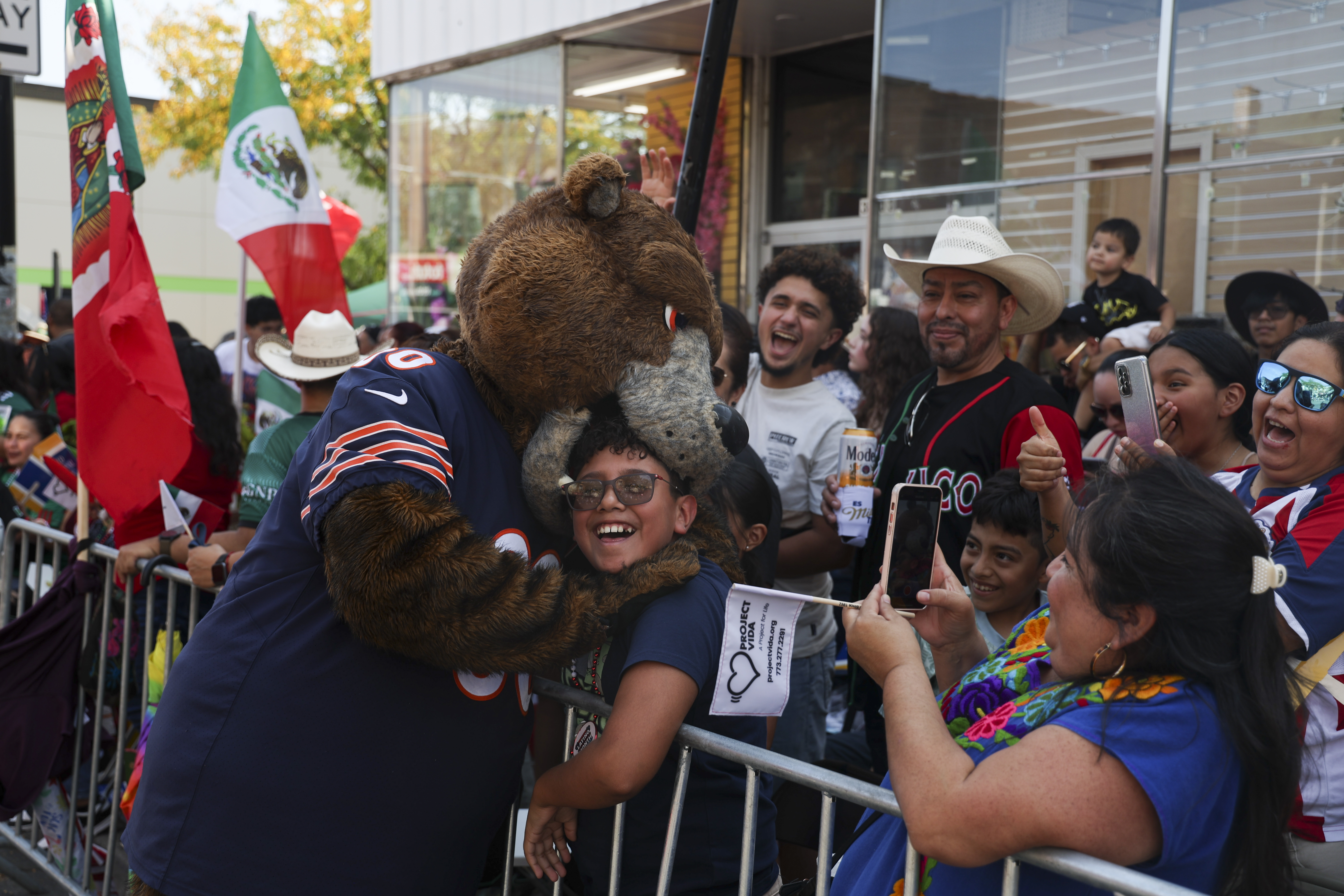 Staley Da Bear pretends to bite a boy's head during the Mexican Independence Day Parade in Little Village on Sunday, Sept. 15, 2024. (Eileen T. Meslar/Chicago Tribune)