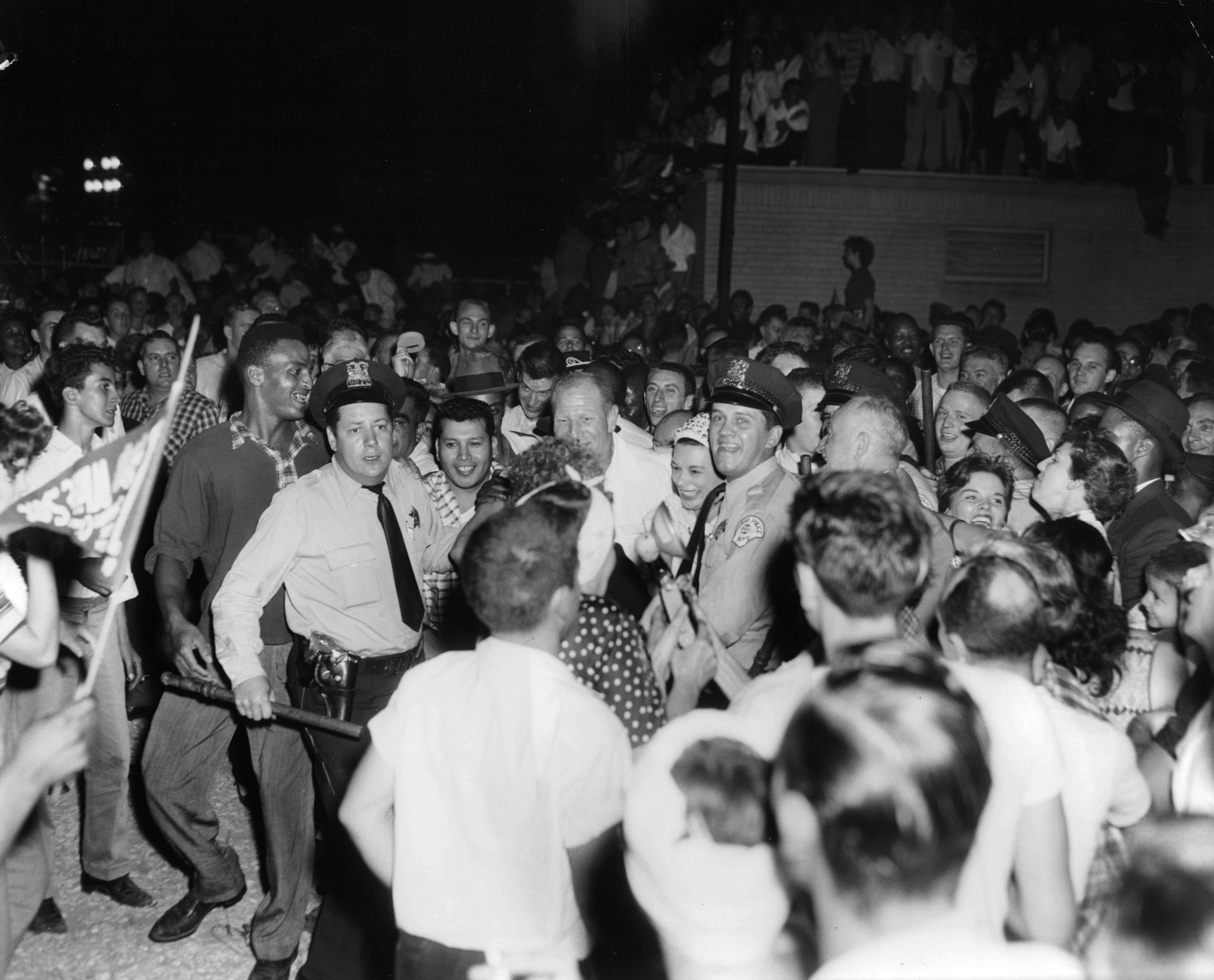 Jubilant fans hail the American League champion White Sox at Midway Airport early in the morning on Sept. 23, 1959, when the team returned from Cleveland, Ohio. Bill Veeck, center, is escorted by police officers through the crowd. (Chicago Tribune historical photo)