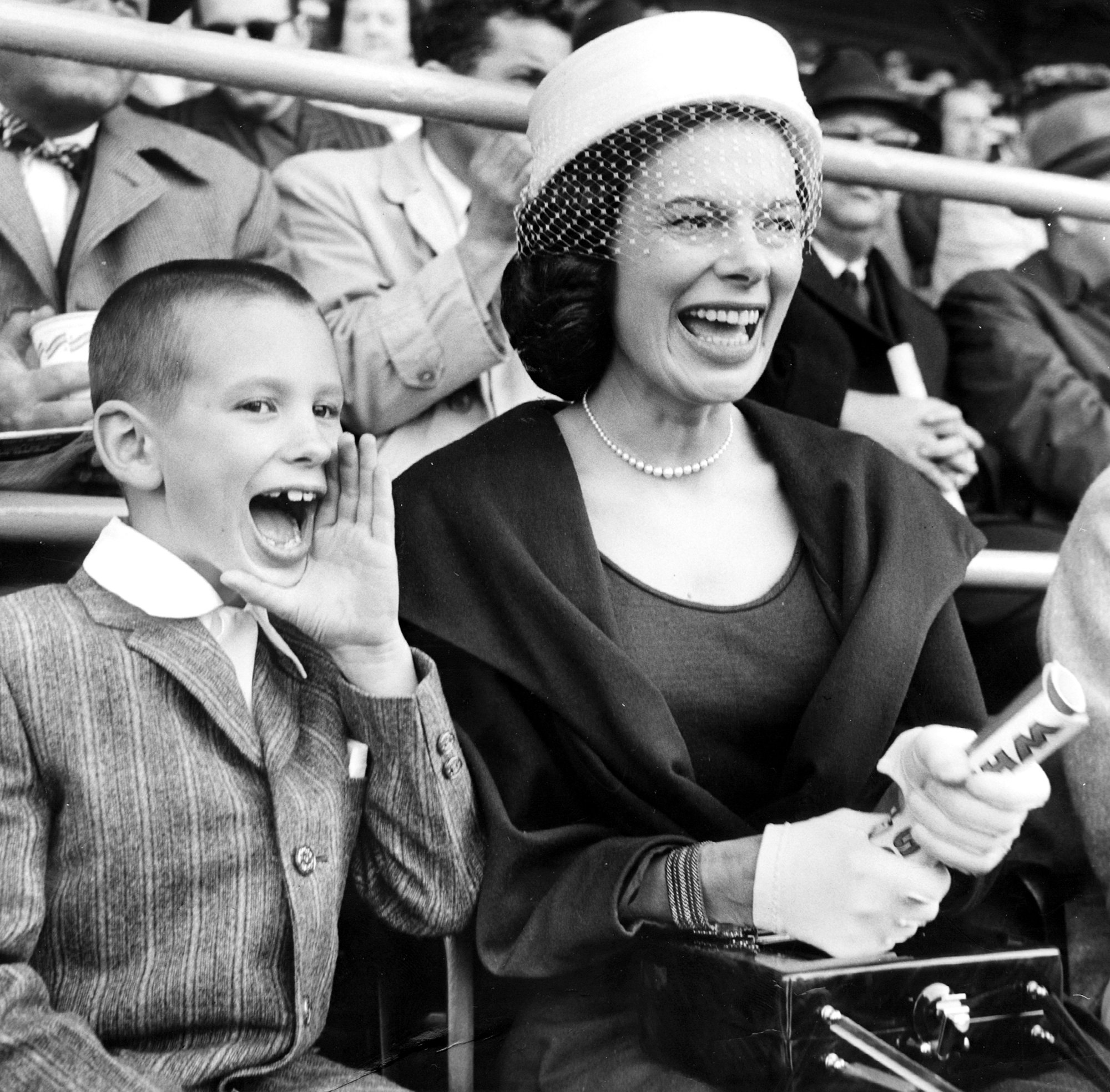 Mary Frances, wife of White Sox owner Bill Veeck, and their son Mike, 8, yell as she twists a program with excitement on Opening Day at Comiskey Park in Chicago on April 14, 1959. (Carl Turk/Chicago Tribune)