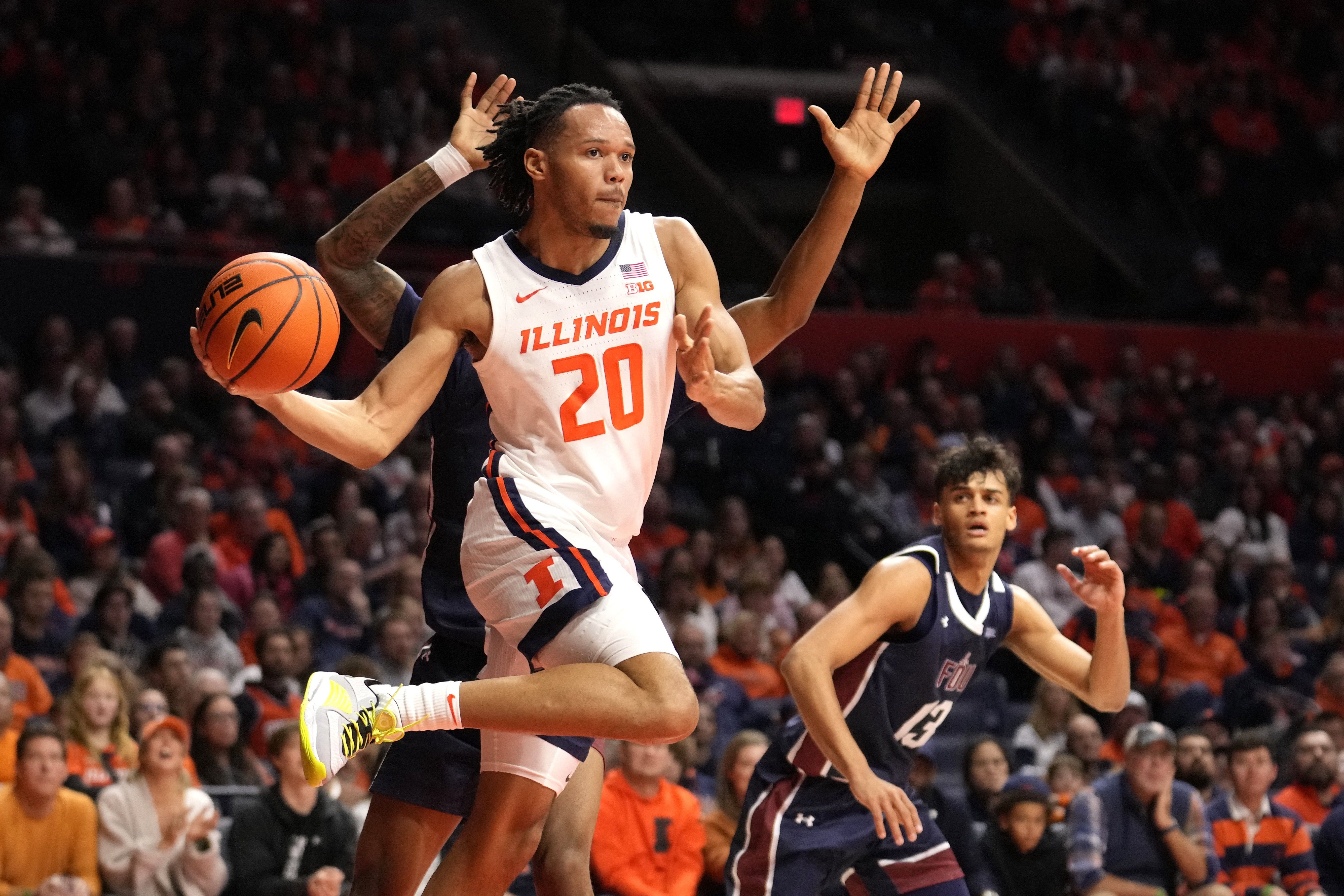 Illinois' Ty Rodgers looks to pass the ball as Fairleigh Dickinson's Sean Moore defends during the first half on Dec. 29, 2023, in Champaign. (AP Photo/Charles Rex Arbogast)