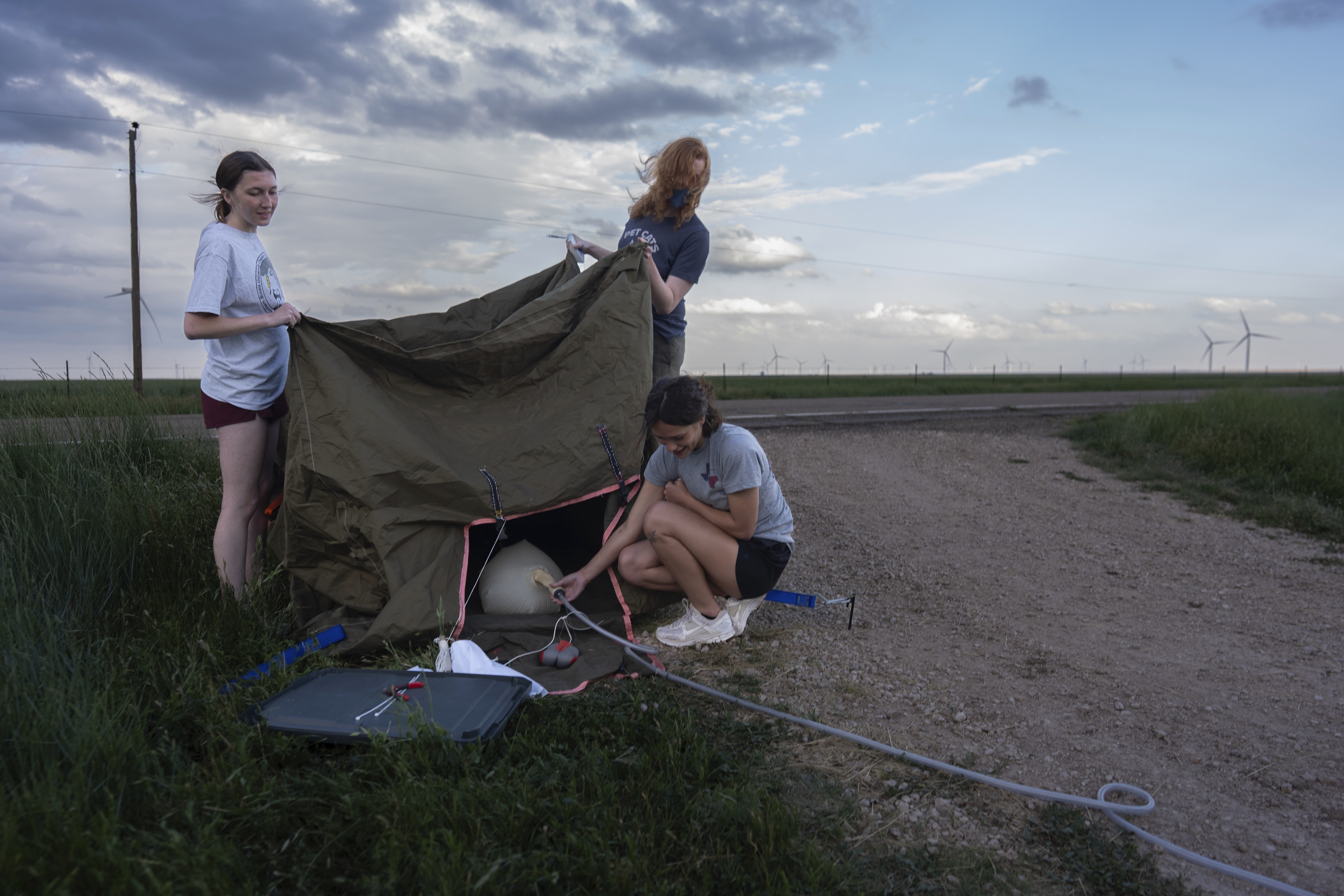 Project ICECHIP members from Northern Illinois University Evelynn Mantia, left, and Olivena Carlisle, lower right, inflate a weather balloon with a radiosonde attached to collect data, June 4, 2025, during a hail study in Tucumcari, New Mexico. (Carolyn Kaster/AP)