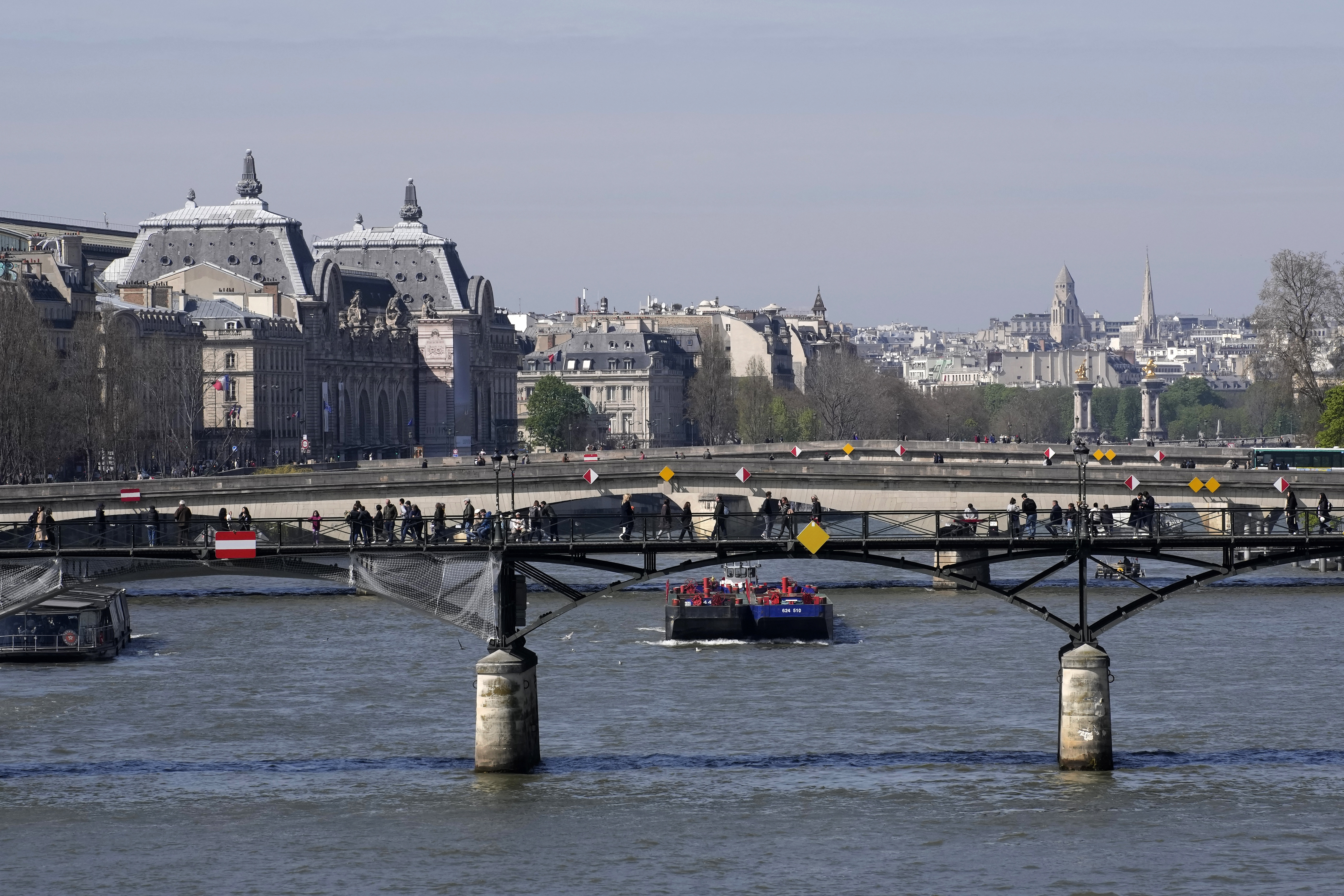 Barges travel along the River Seine in Paris, on April 5, 2023.