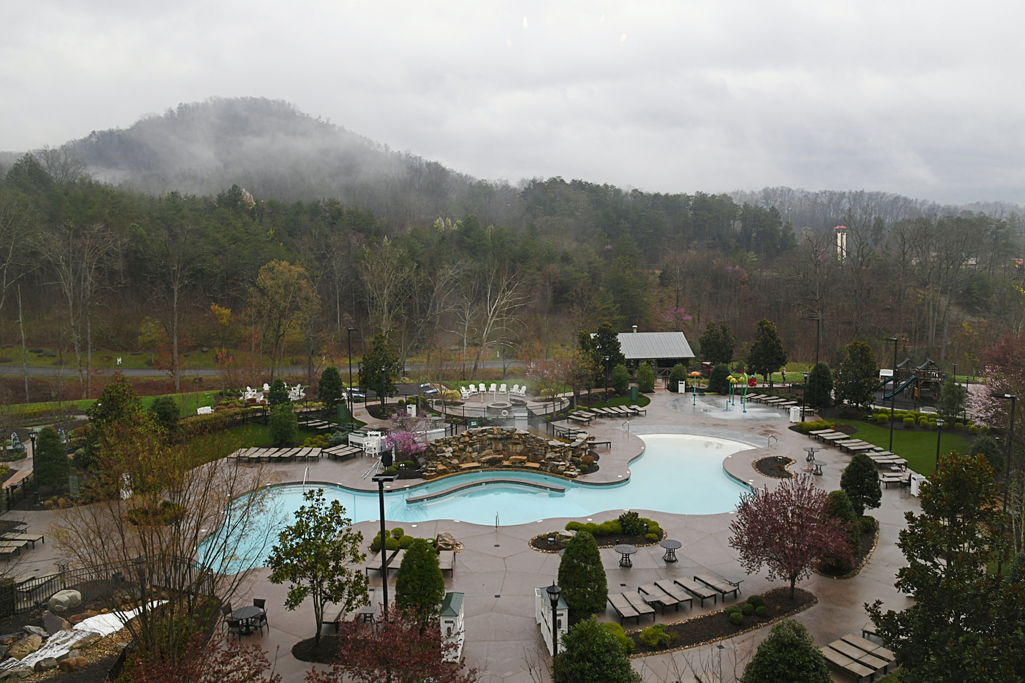 Outdoor amenities at Dollywood's DreamMore Resort & Spa include Adirondack chairs around a fire pit, a hot tub, a pool, a playground, and yard games, on Friday, March 10, 2023, in Pigeon Forge, Tennessee. (Linze Rice/for the Chicago Tribune)