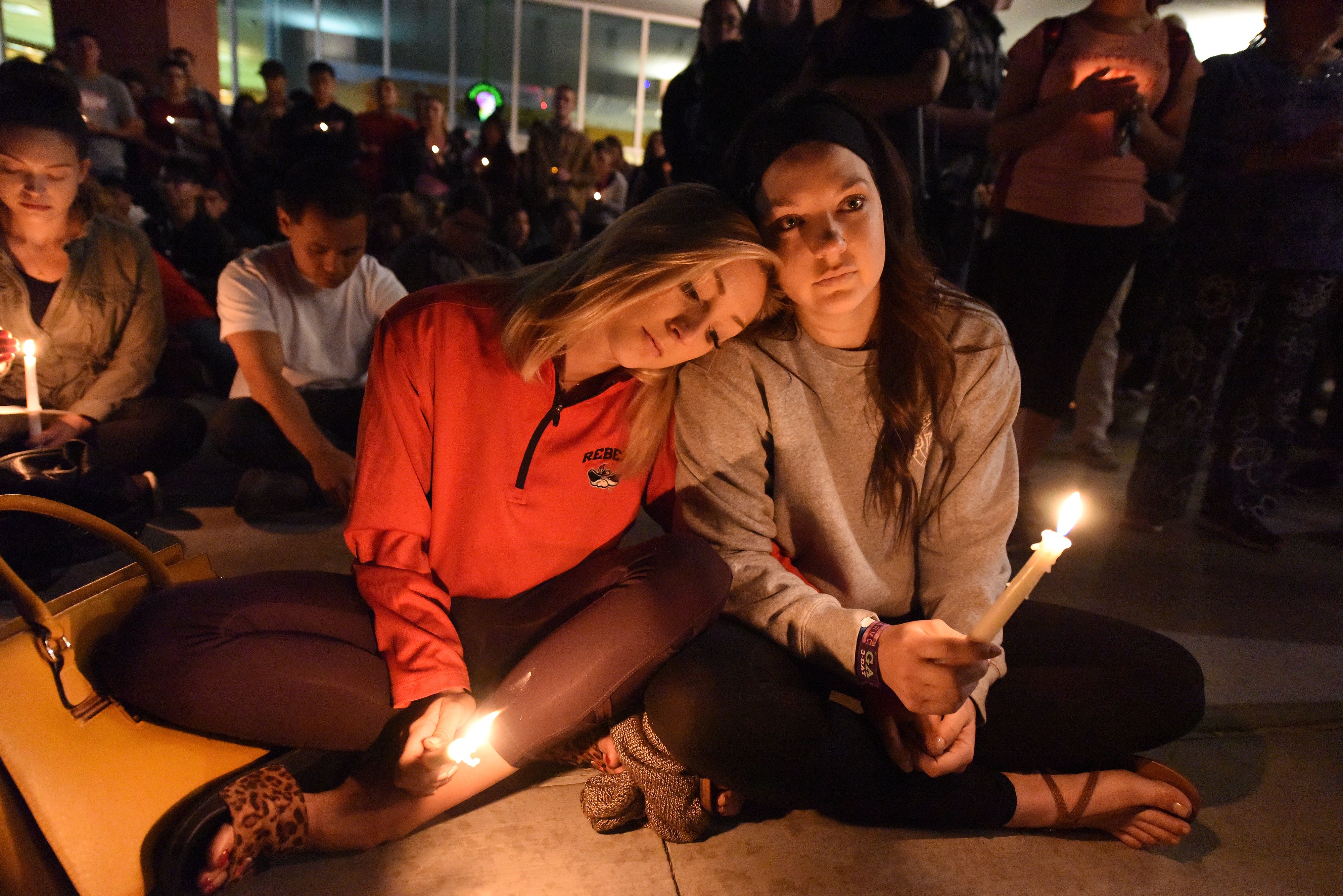 Lindsay Cotterman (L) and Shawna Pieruschka attend a candlelight vigil at the University of Las Vegas student union October 2, 2017, after a gunman killed at least 58 people and wounded more than 500 others when he opened fire on a country music concert in Las Vegas, Nevada late October 1, 2017.