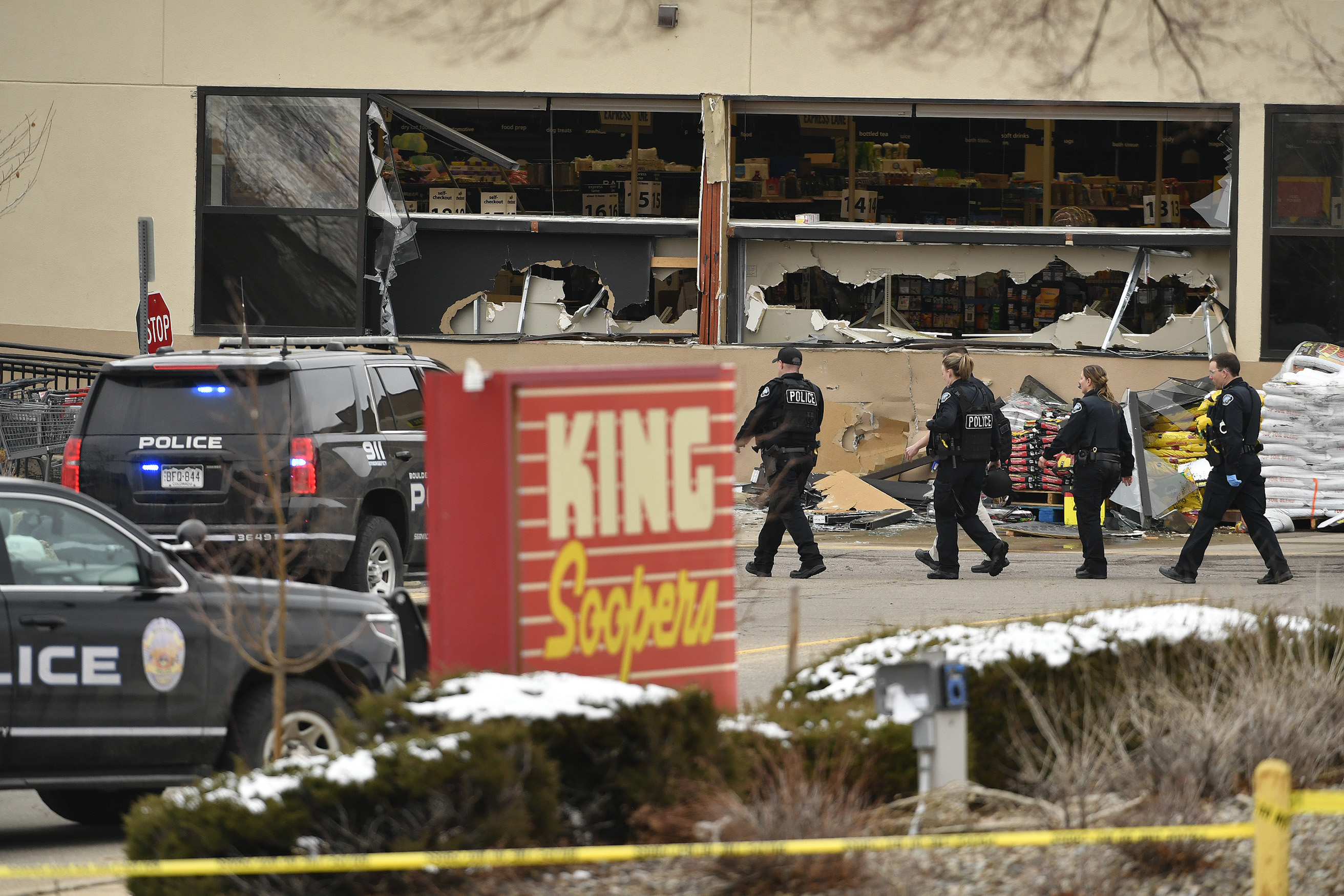 Law enforcement officers wait outside the ...