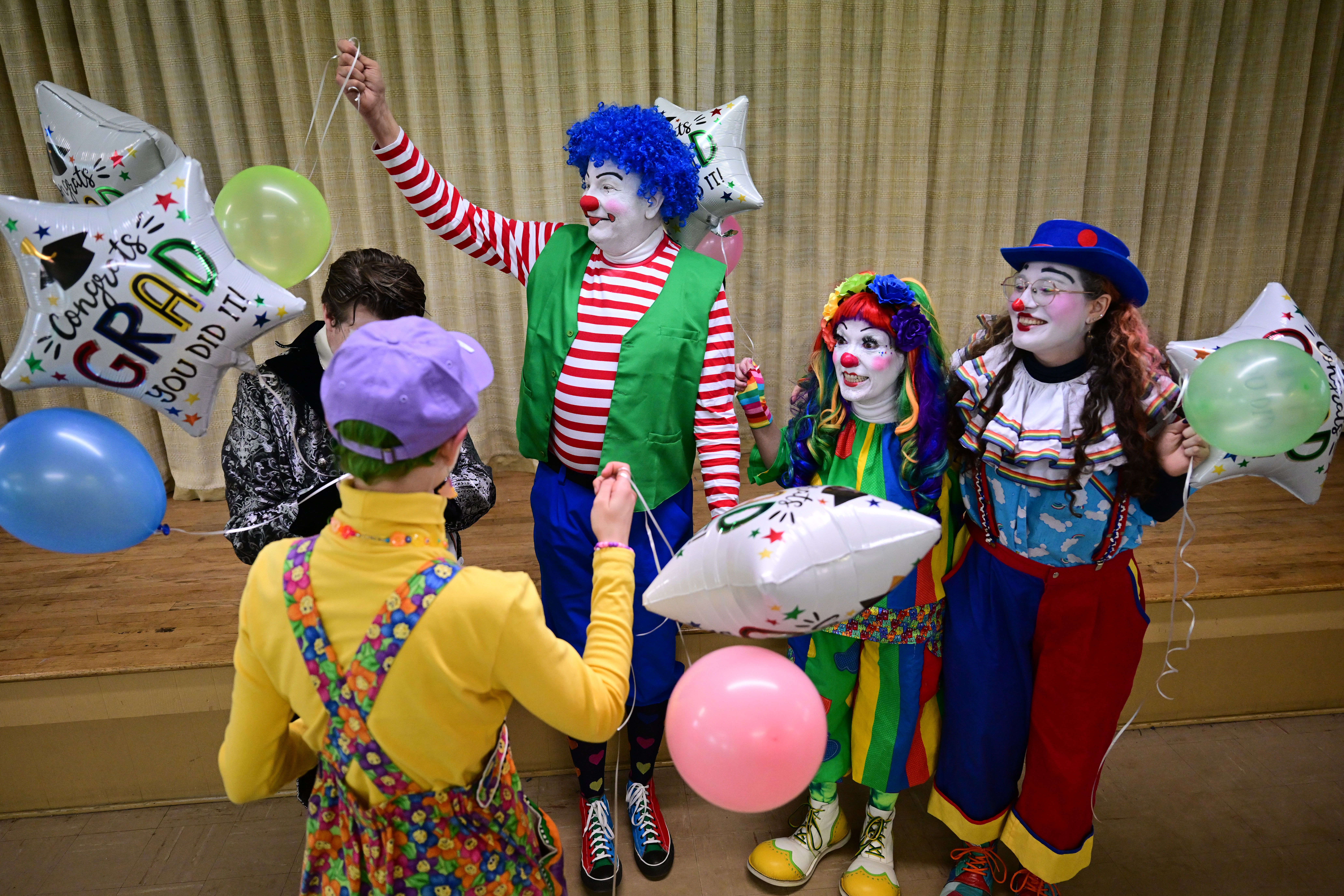 Emily Cooper, aka Lollygag the clown, far right, celebrates her graduation with the other clowns graduating from Colorado Clown Alley on March 12, 2023, in Englewood. The clowns are from left to right: Knick Knack aka Kay Begley, with back to camera, Mr. Fancy Pants aka Braeden Schilling-Smith, Waldo, aka John Urschel, Sassy, aka Lainie Chmiel, and Cooper. (Photo by Helen H. Richardson/The Denver Post)