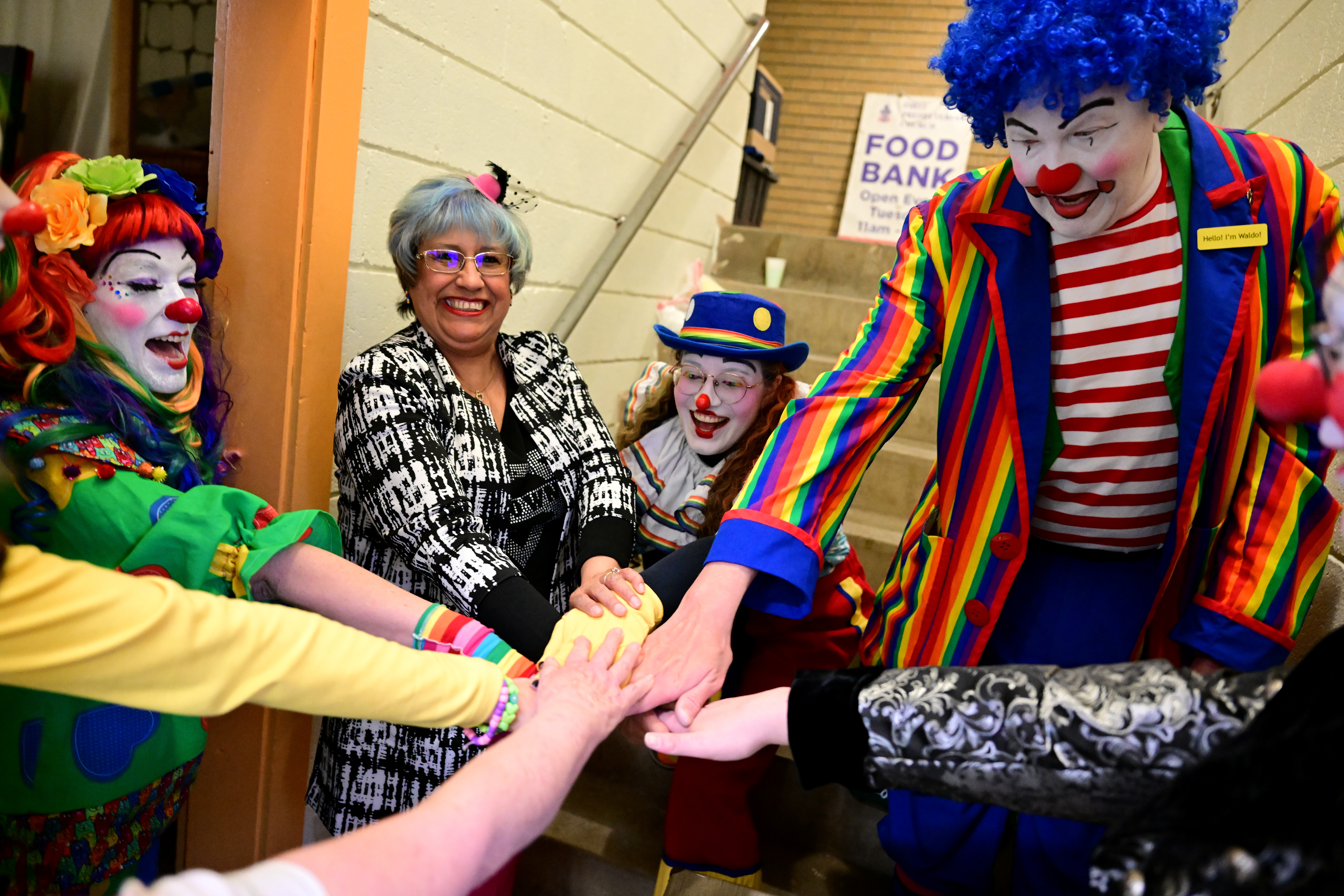 Isabel Nuanez, president of Colorado Clown Alley, second from left, gets her clowns to say a cheer before they hit the stage for their skit during the group's graduation from Colorado Clown Alley on March 12, 2023 in Englewood. The clowns are from left to right: Sassy or Lainie Chmiel, Lollygag, or Emily Cooper, and Waldo or John Urscher, right, (Photo by Helen H. Richardson/The Denver Post)