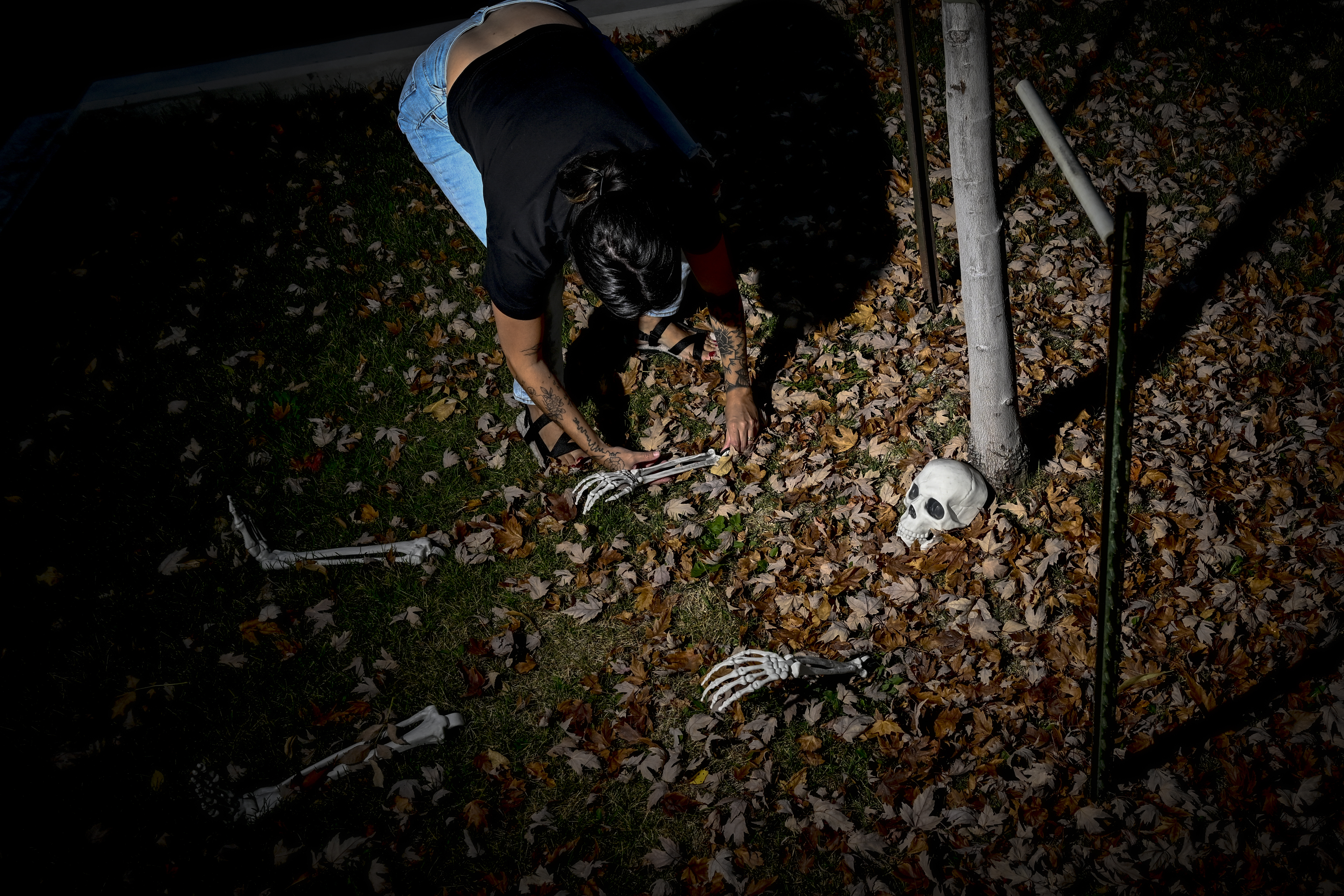 Erin Moriarty-Siler digs a leafy grave for an unnamed skeleton at her home in Denver on Wednesday, October 25, 2023. Erin received a large decorative skeleton named Fred the Dead as an anniversary gift from her husband, which she said brought her to tears. (Photo by AAron Ontiveroz/The Denver Post)