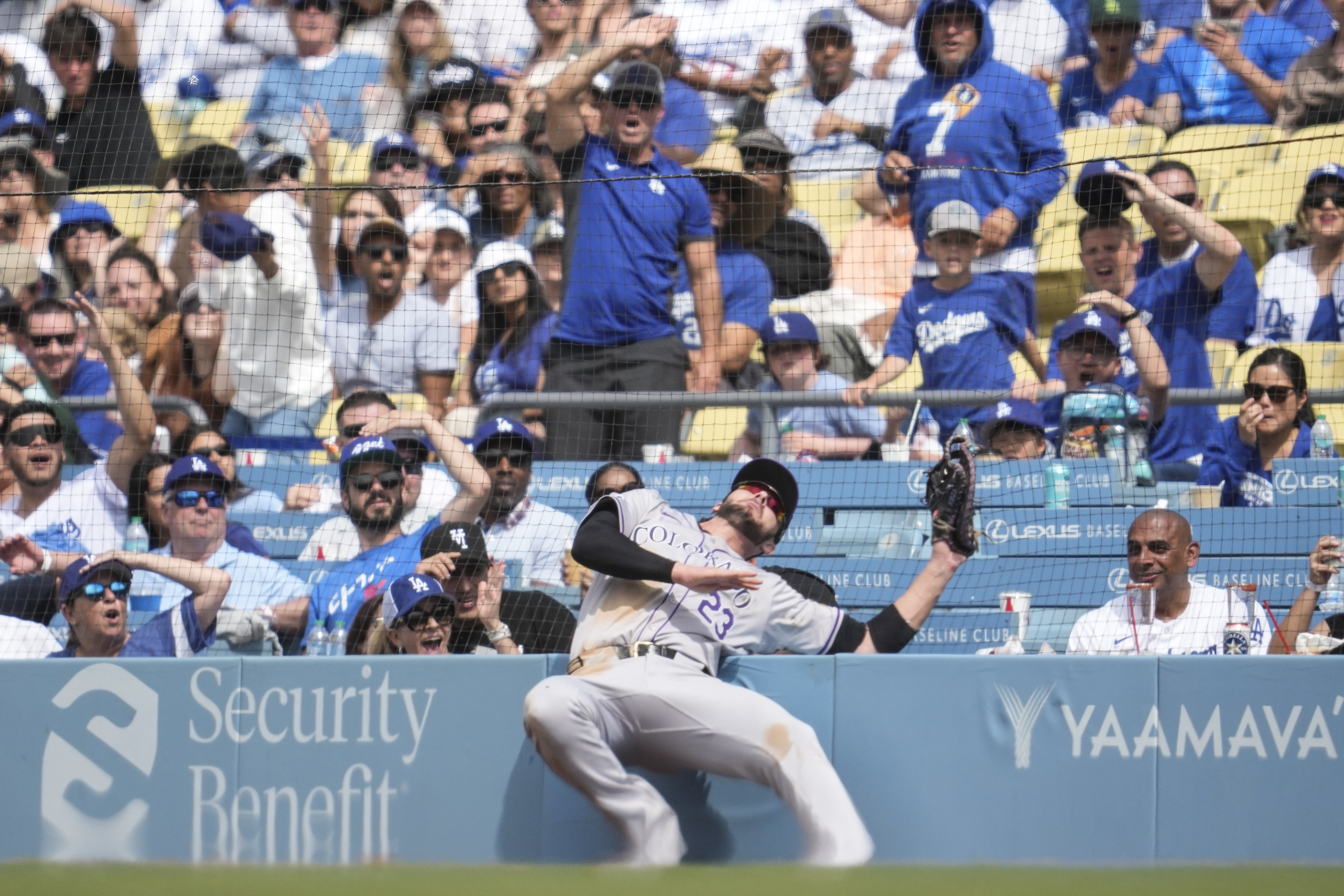 Colorado Rockies first baseman Kris Bryant (23) catches a foul ball hit by Los Angeles Dodgers' Mookie Betts during the eighth inning of a baseball game in Los Angeles, Sunday, June 2, 2024. (AP Photo/Ashley Landis)