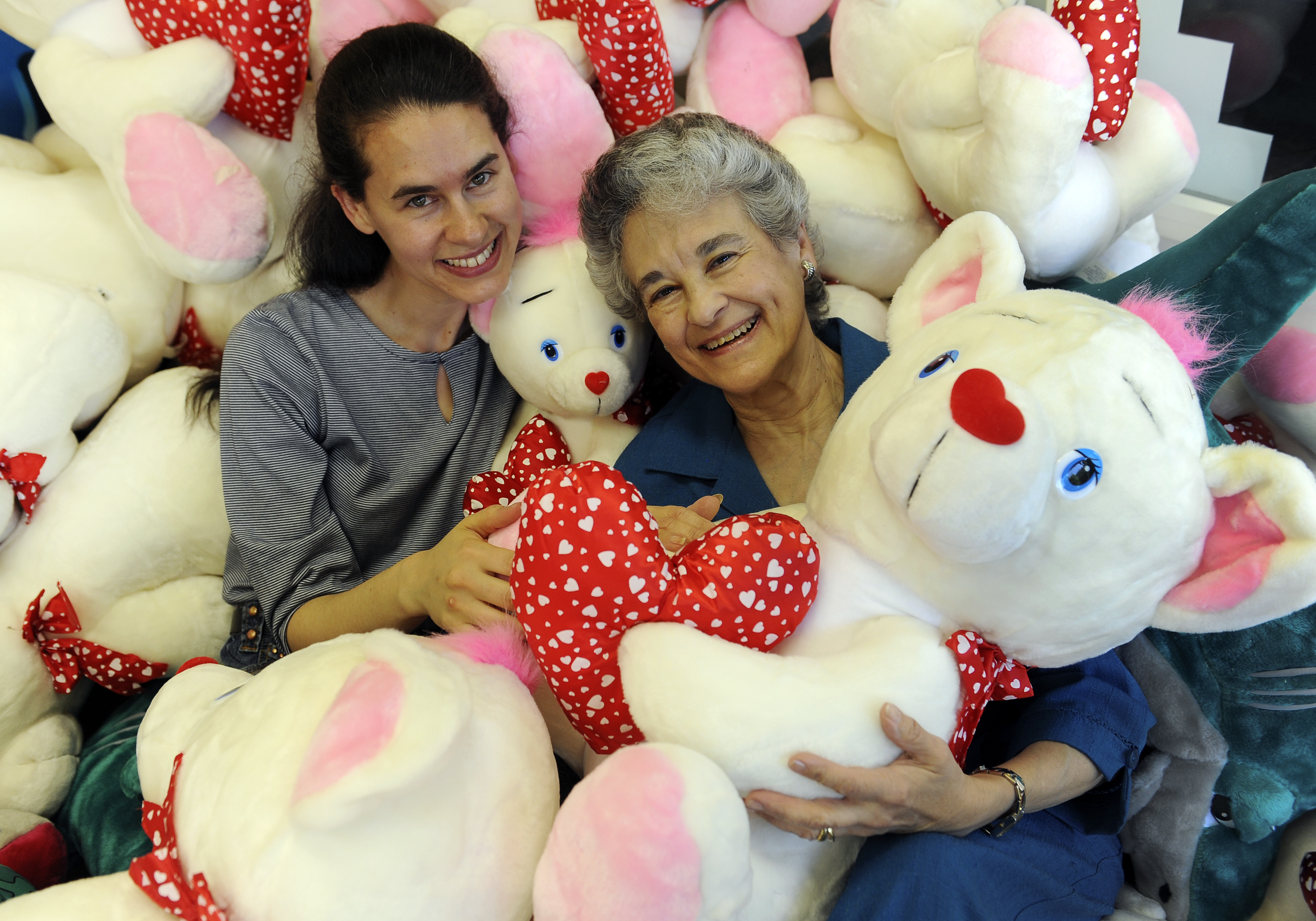 Brenda Fishman, left, and her mother Rhoda Krasner, right, cuddled with prizes inside a game on Friday night, June 24, 2011. (Karl Gehring/ The Denver Post)