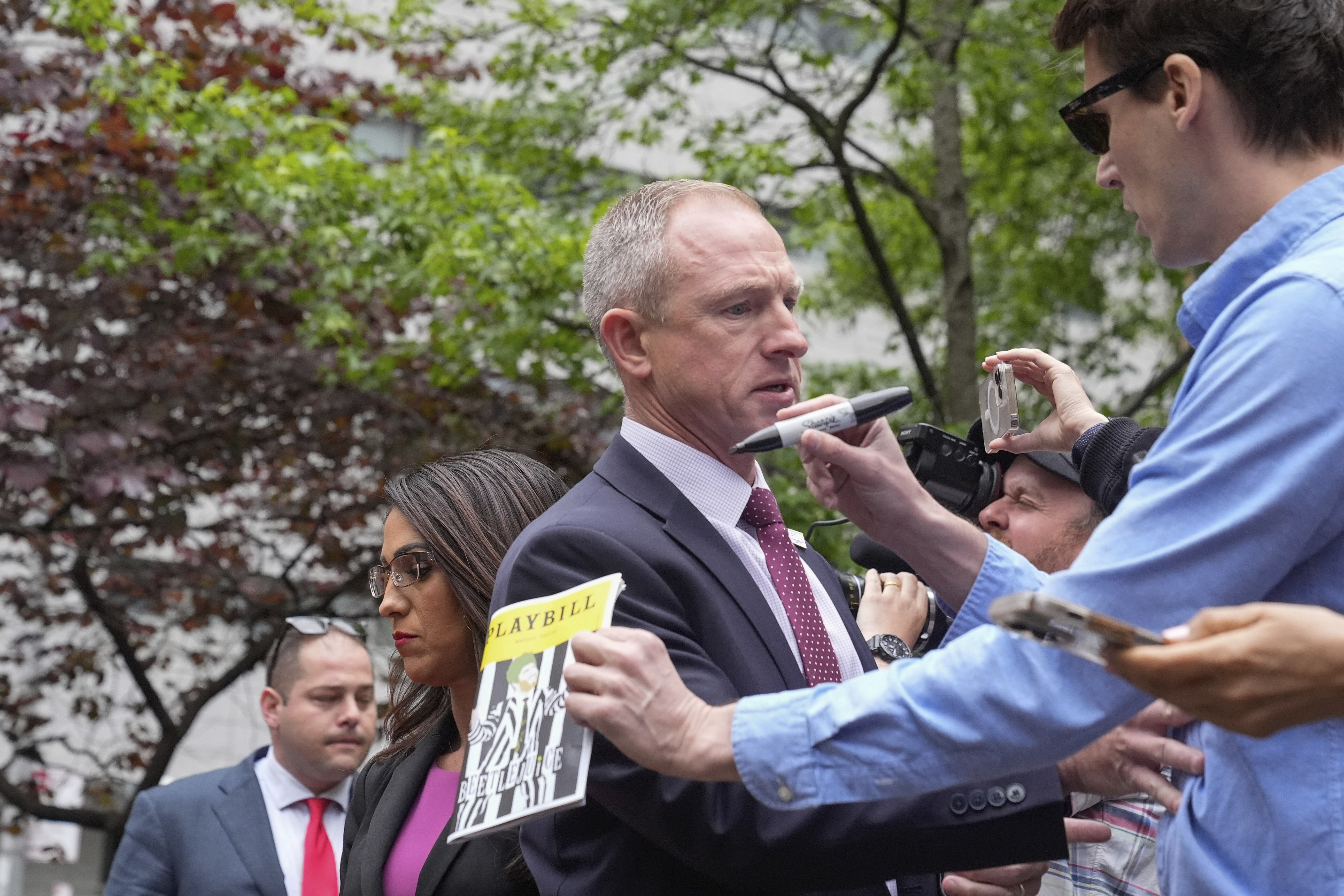 Security stops a person holding a "Beetlejuice" playbill and pen from approaching U.S. Rep. Lauren Boebert, R-Colo., during a news conference near Manhattan Criminal Court outside Donald Trump's hush-money trial on May 16, 2024, in New York. (AP Photo/Frank Franklin II)