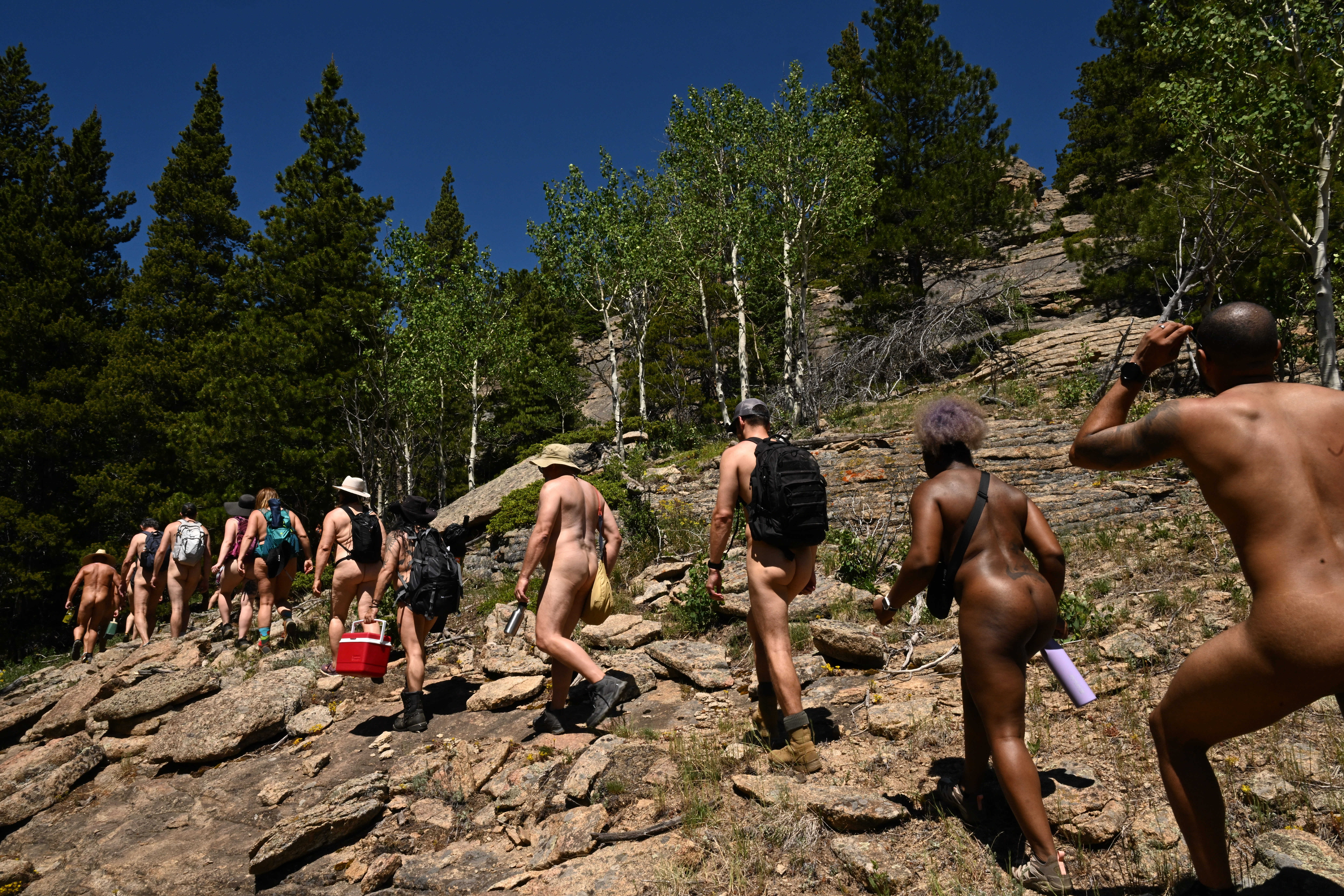 Hikers make their way through the woods as they hike with members of the Rocky Mountain Naturist Club at the Iron Aspen Ranch near Lyons, Colorado on June 23, 2024. Owner Mickey Haggerty hosts members of the Rocky Mountain Naturist Club -- naturist being the term for a non-sexual nudist -- on hikes on his property. (Photo by Helen H. Richardson/The Denver Post)