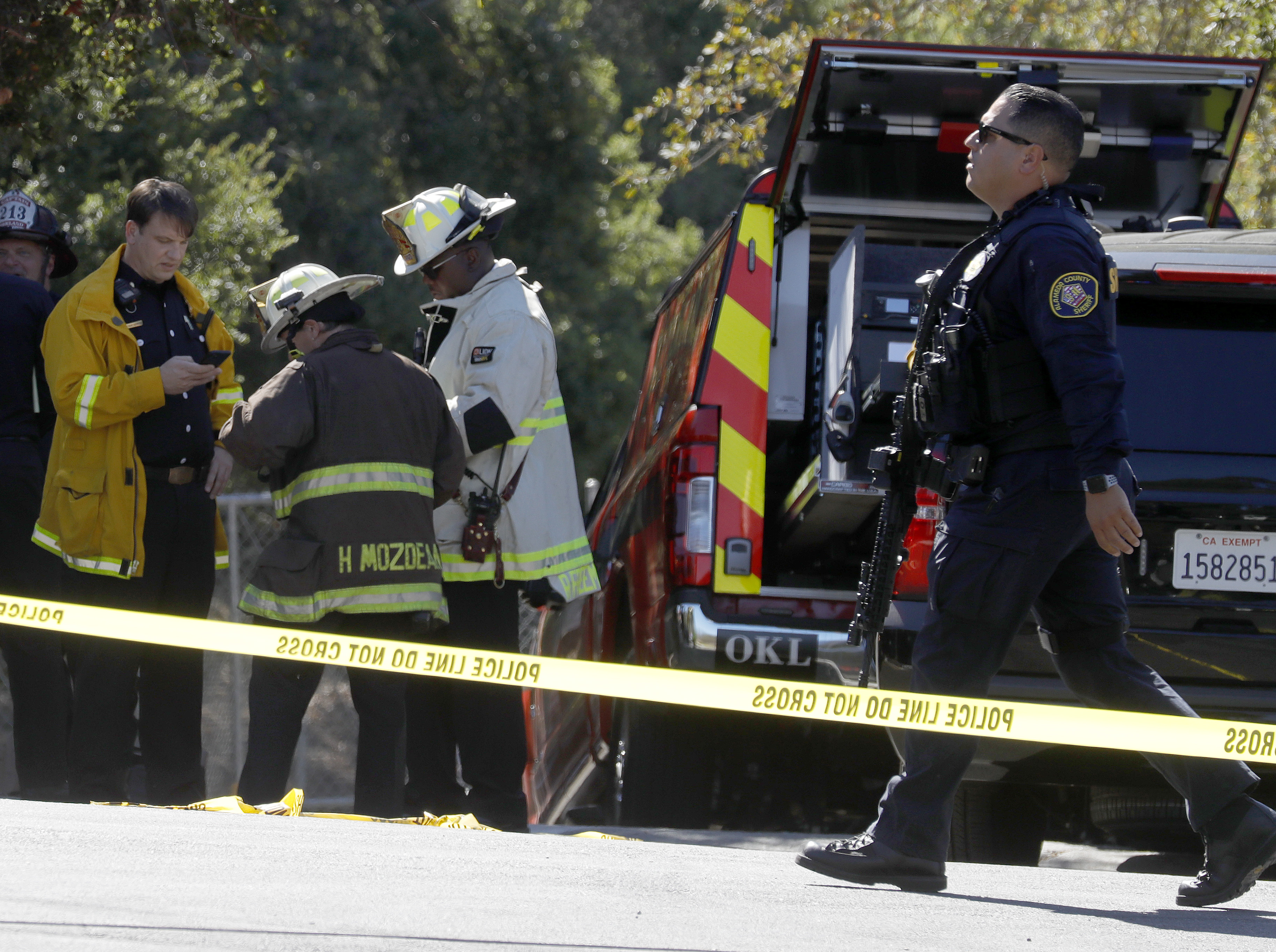 OAKLAND, CALIFORNIA - SEPTEMBER 28: An Alameda County Sheriff's Department deputy carries an automatic rifle as law enforcement officers from several agencies respond after at least six adults were shot at the Bay Area Technology School complex in East Oakland, Calif., on Wednesday, Sept. 28, 2022. (Jane Tyska/Bay Area News Group)