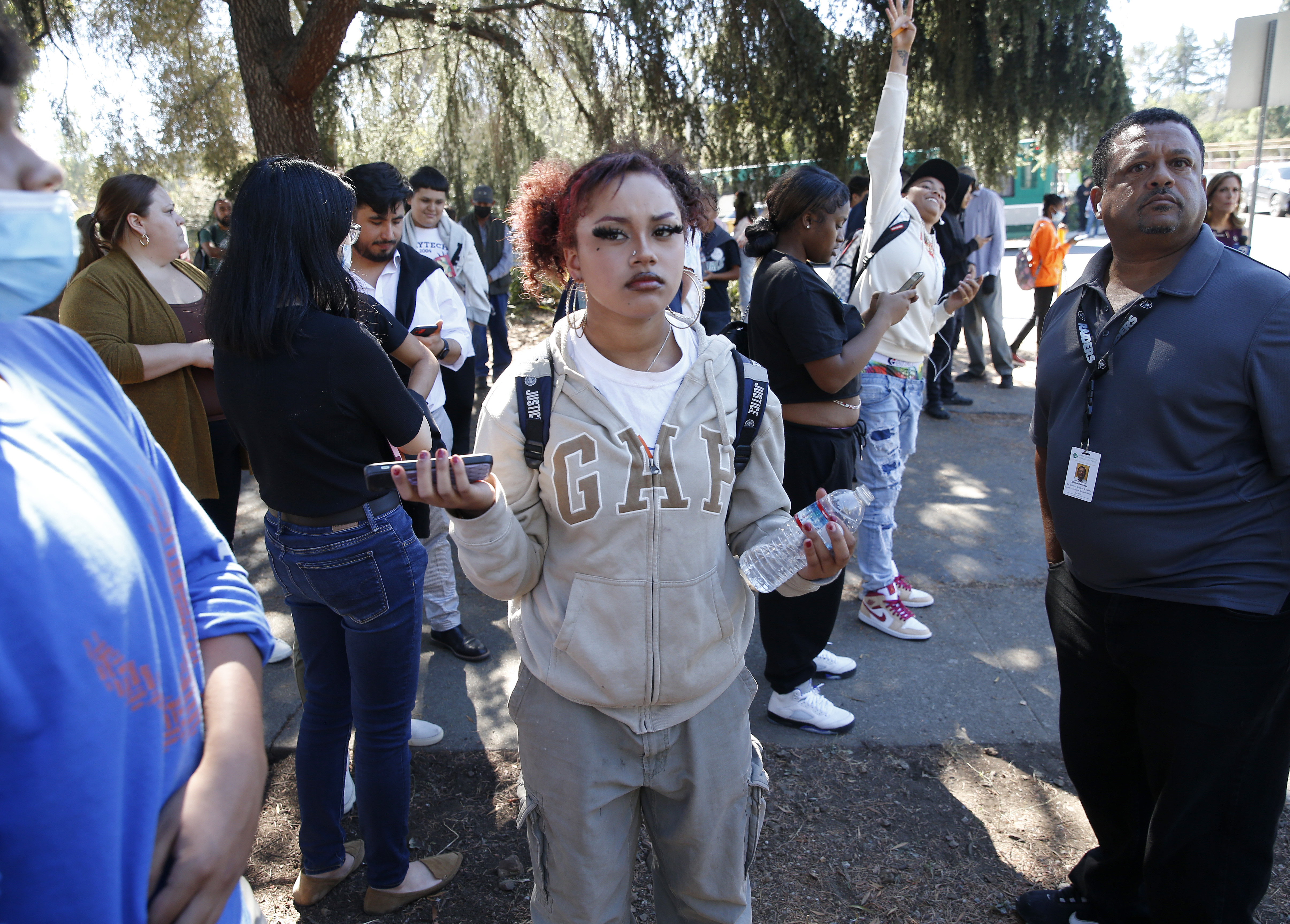 OAKLAND, CALIFORNIA - SEPTEMBER 28: Students and administrators gather at St. Cuthbert's Episcopal Church on Mountain Boulevard and Keller Avenue as law enforcement officers from several agencies respond after at least six adults were shot at the Bay Area Technology School complex in East Oakland, Calif., on Wednesday, Sept. 28, 2022. (Jane Tyska/Bay Area News Group)