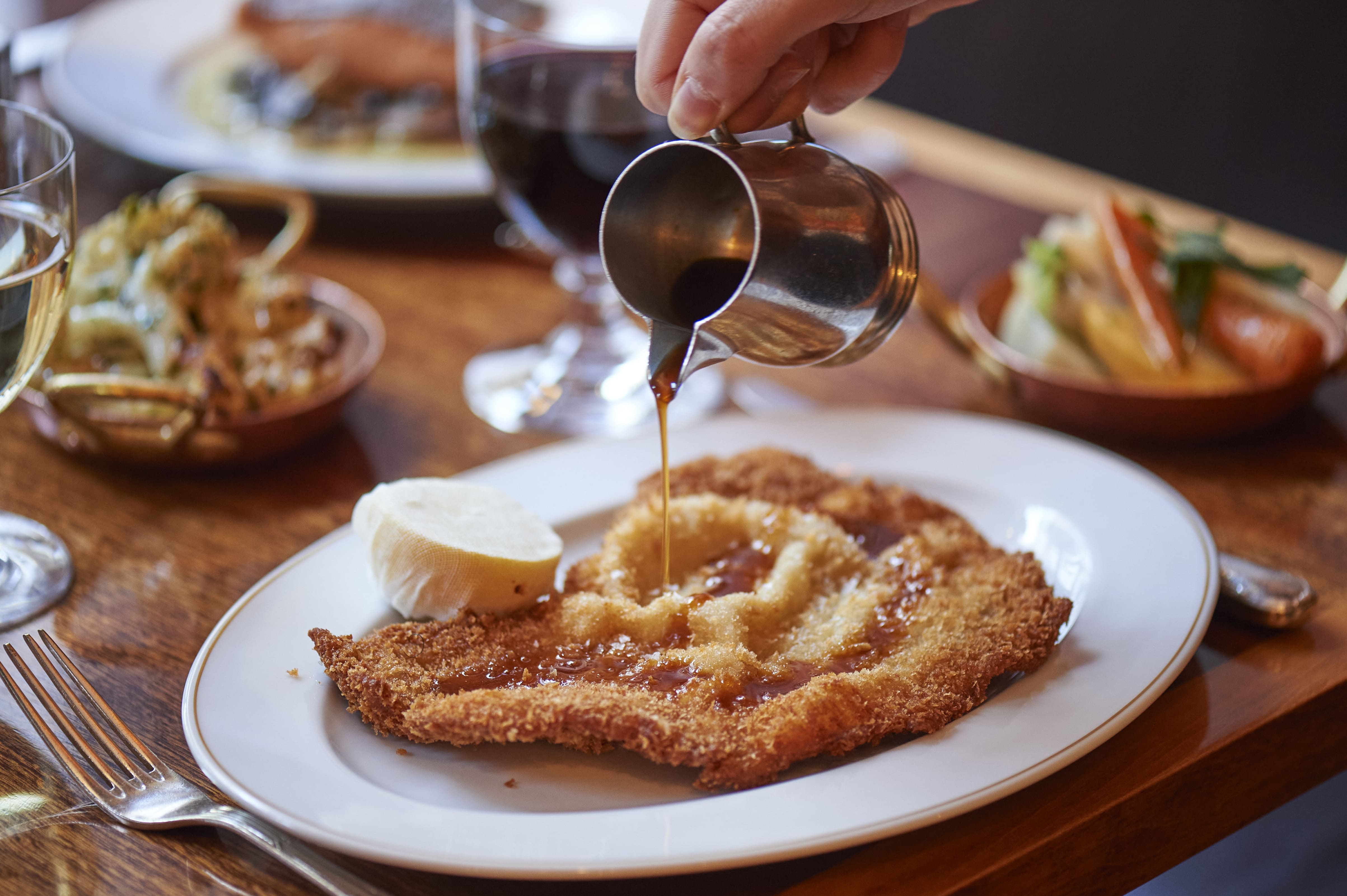 Weiner Schnitzel with lemon and gravy being poured over the top