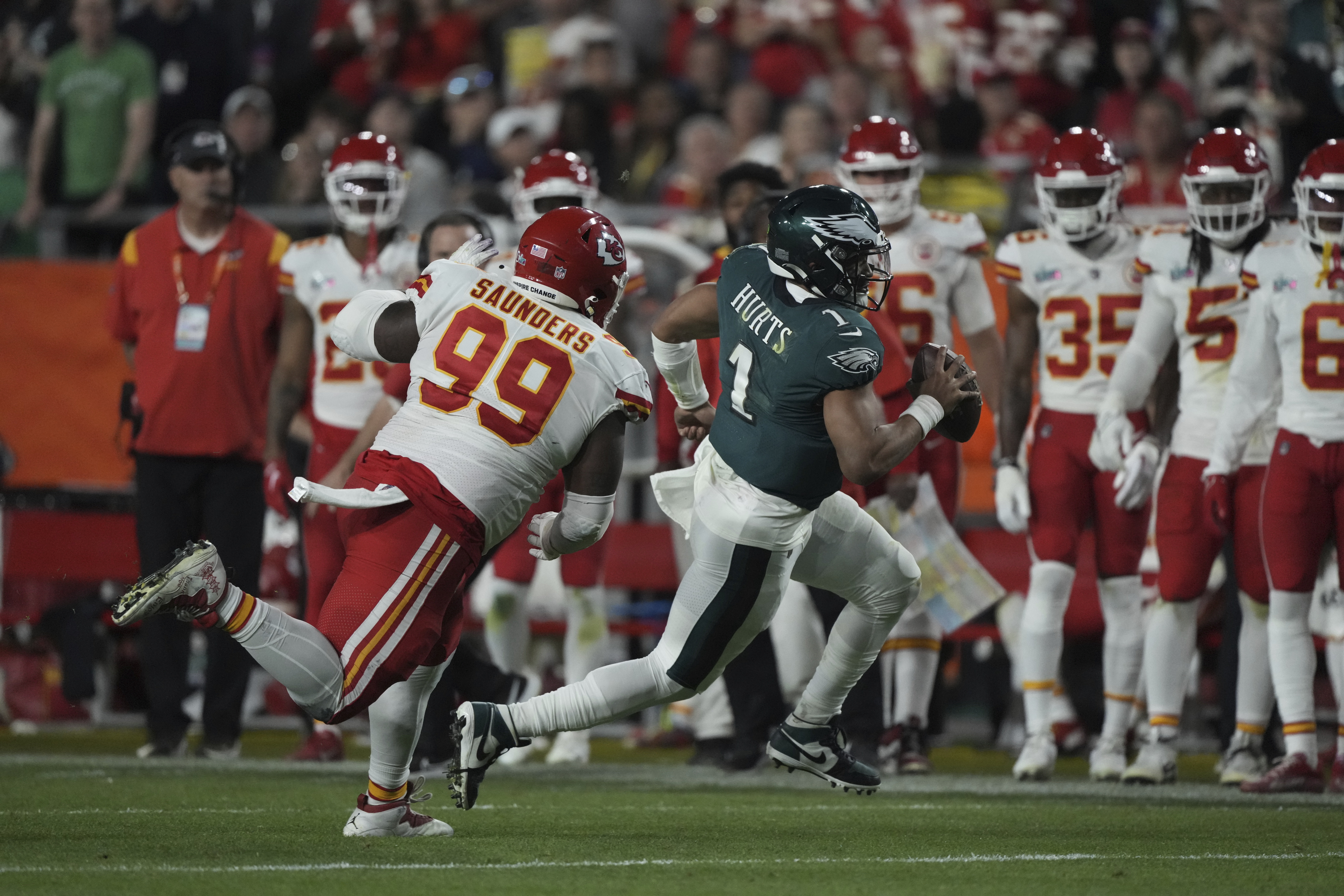 Philadelphia Eagles quarterback Jalen Hurts (1) scrambles away from Kansas City Chiefs defensive tackle Khalen Saunders (99) during the NFL Super Bowl 57 football game, Sunday, Feb. 12, 2023, in Glendale, Ariz. (AP Photo/Doug Benc)