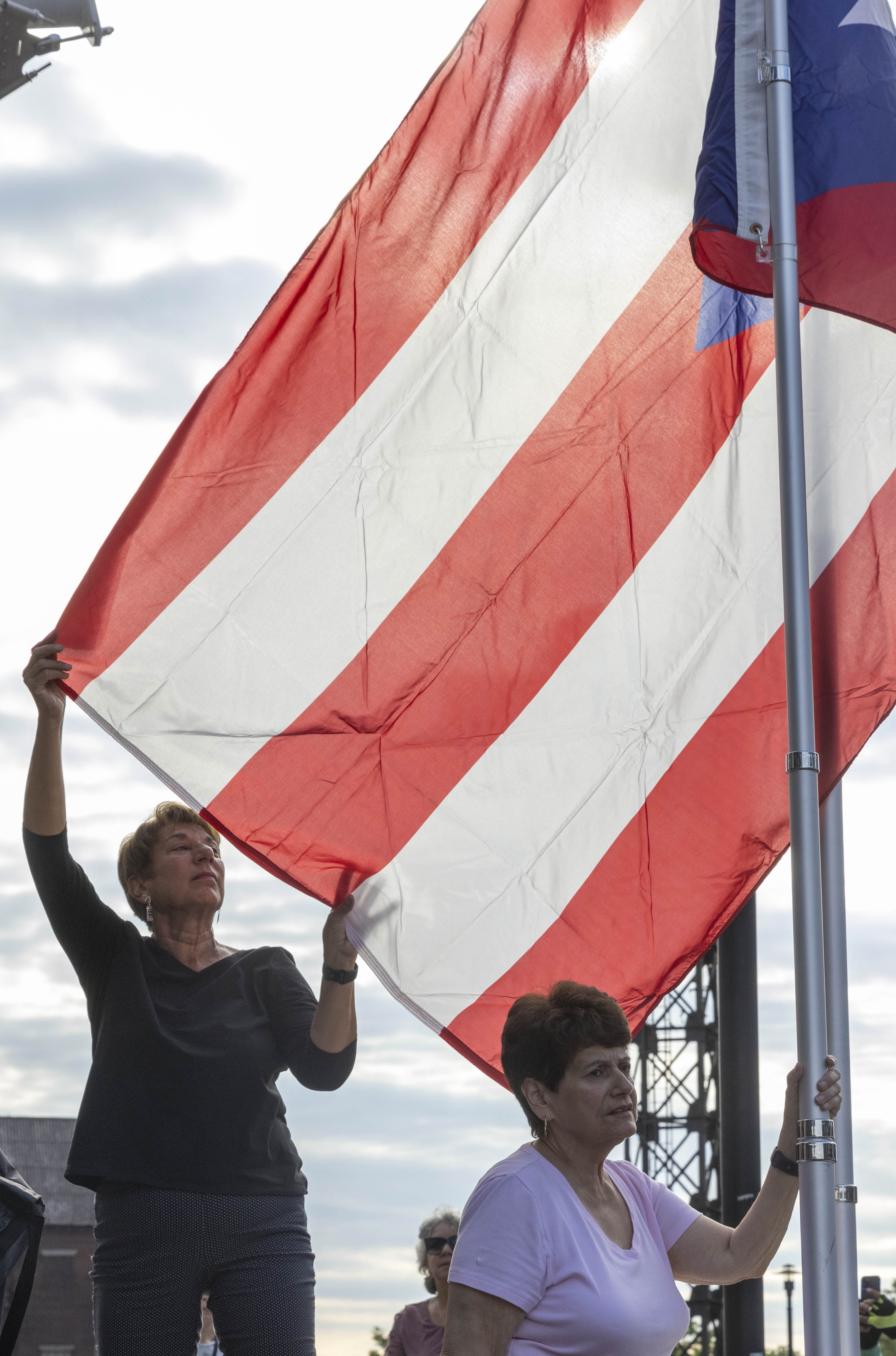 An attendee raises the Puerto Rican flag Friday, June 28, 2024, during the 13th annual ¡Sabor! Latin Festival at SteelStacks in Bethlehem. The festival is a celebration of Latin heritage including music, food and family fun. (Emma Reed/The Morning Call)