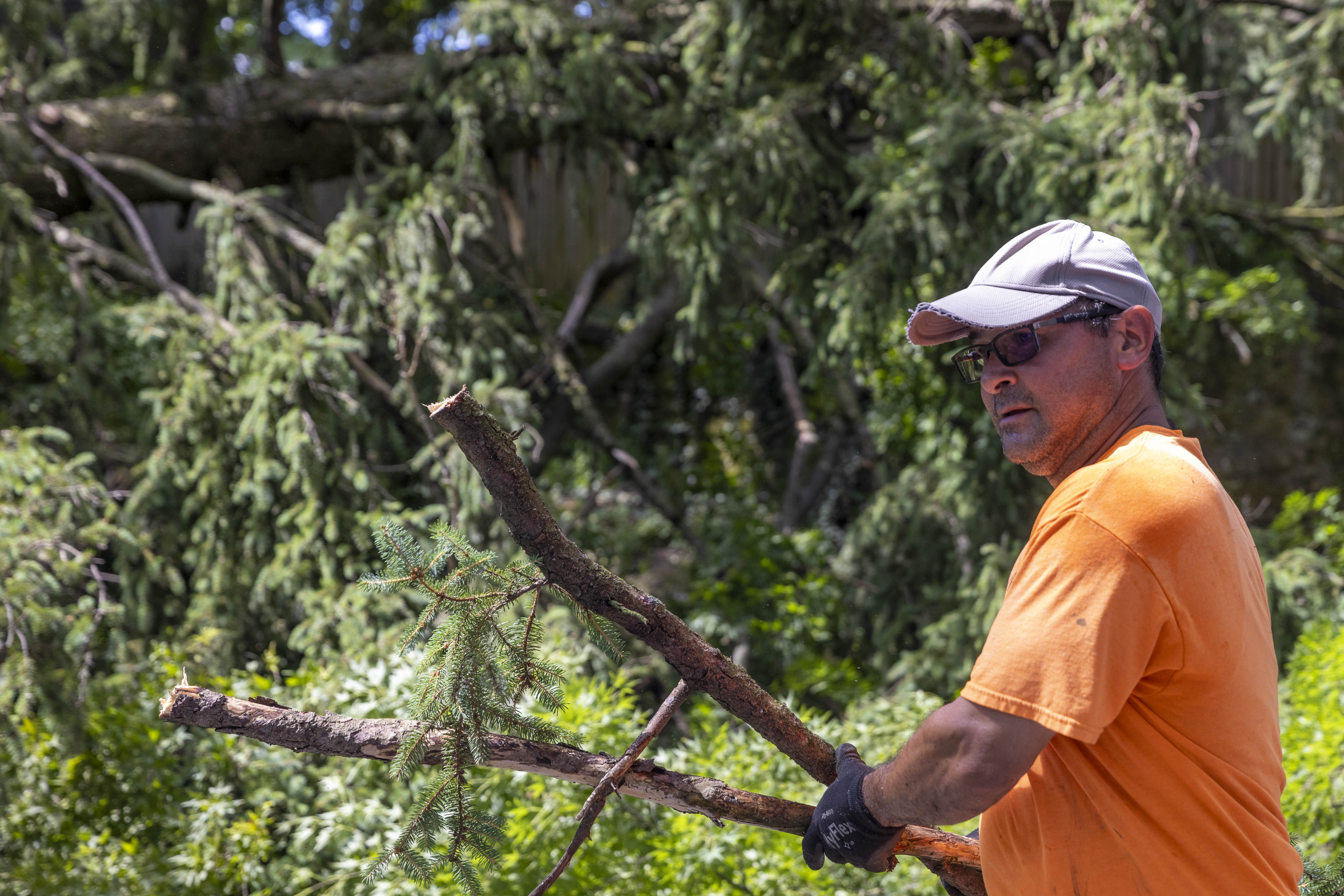Alfredo Burgos, an employee at Muhlenberg College's Plant Operations, moves tree branches Thursday, June 27, 2024, in Allentown after a severe thunderstorm with nearly 60 mph wind gusts ripped through the Lehigh Valley the night before. (Emma Reed/The Morning Call)