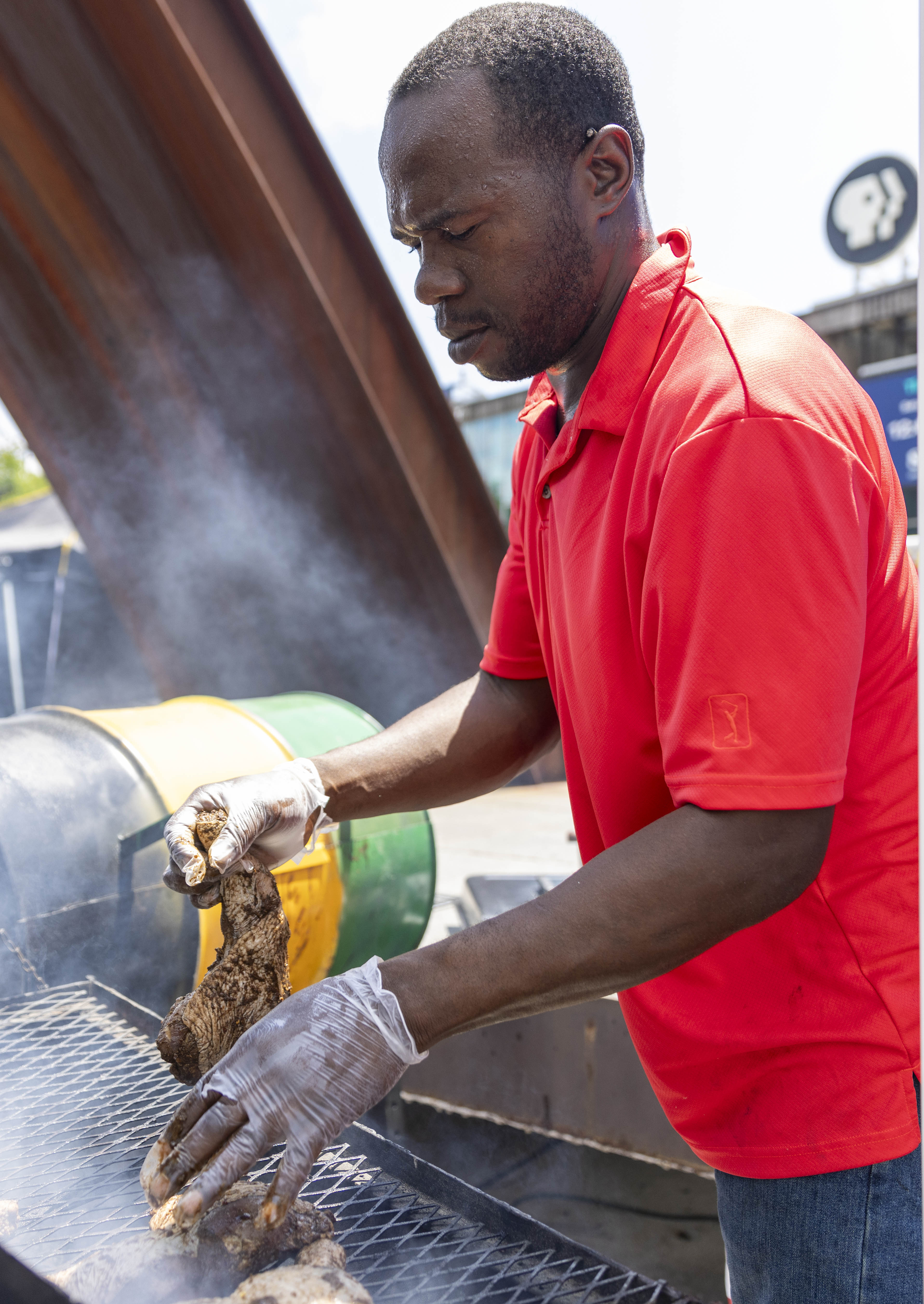 A vendor prepares food for visitors to the One Earth ReggaeFest on Saturday, July 6, 2024, at SteelStacks in Bethlehem. (Emma Reed/The Morning Call)