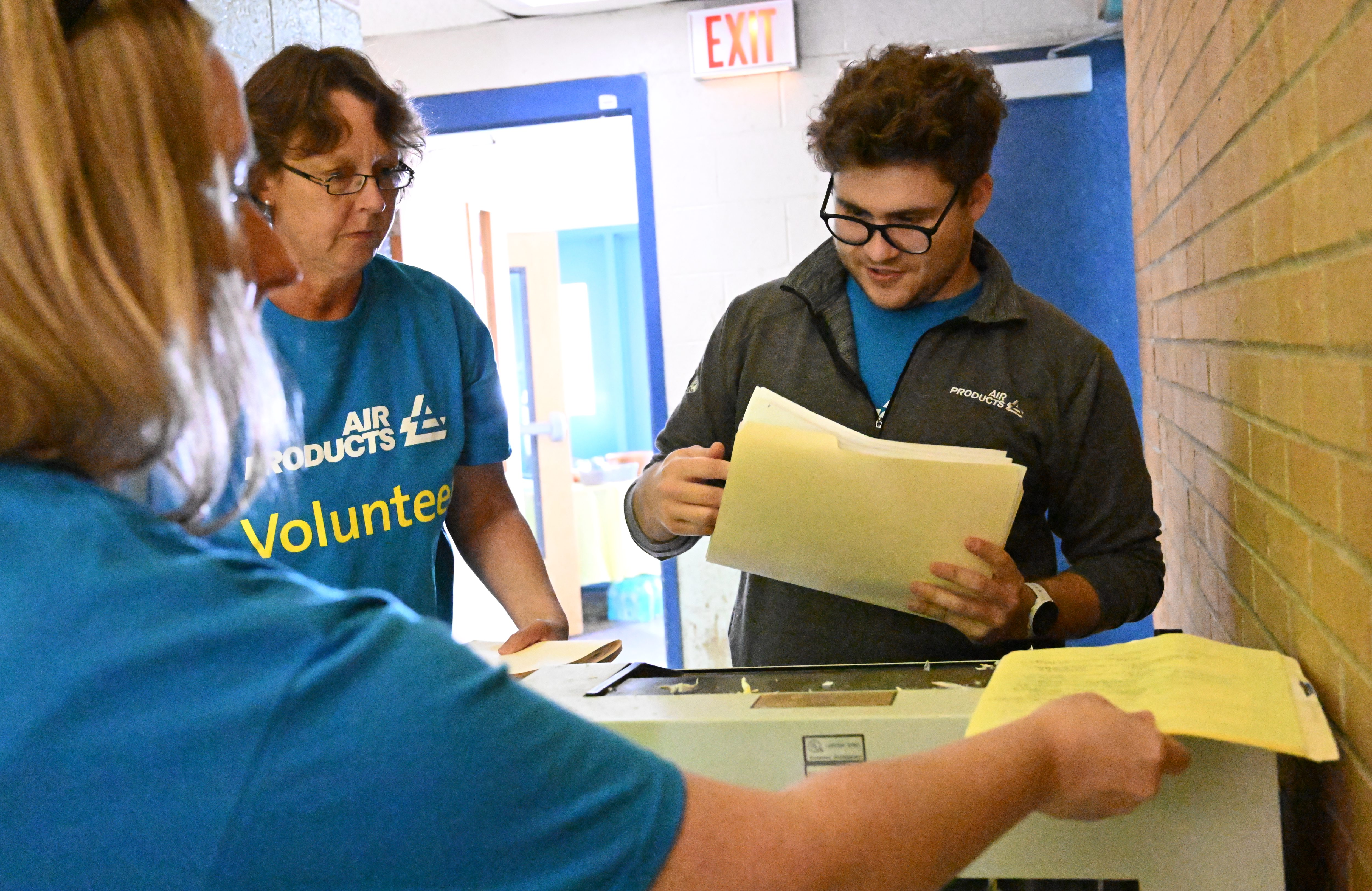 Air Products employees Lioba Kloppenburg, left, Katie Bansner, rear left, and Andrew Dinka shred documents Thursday, Sept. 19, 2024, at the Boys & Girls Club of Allentown during the United Way of the Greater Lehigh Valley's 31st annual Day of Caring. Approximately 2,300 volunteers from 54 area businesses completed community service projects at dozens of nonprofits throughout Lehigh and Northampton counties. (Amy Shortell/The Morning Call)