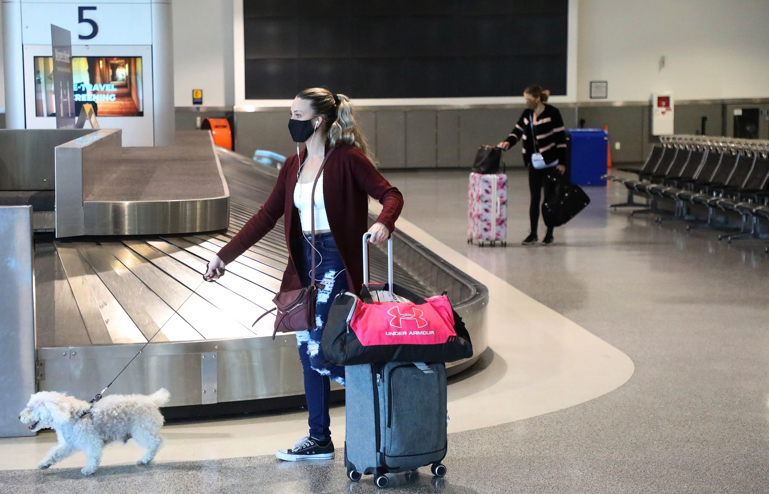 Travelers in baggage claim area at Oakland International Airport Terminal 2, December 2020.