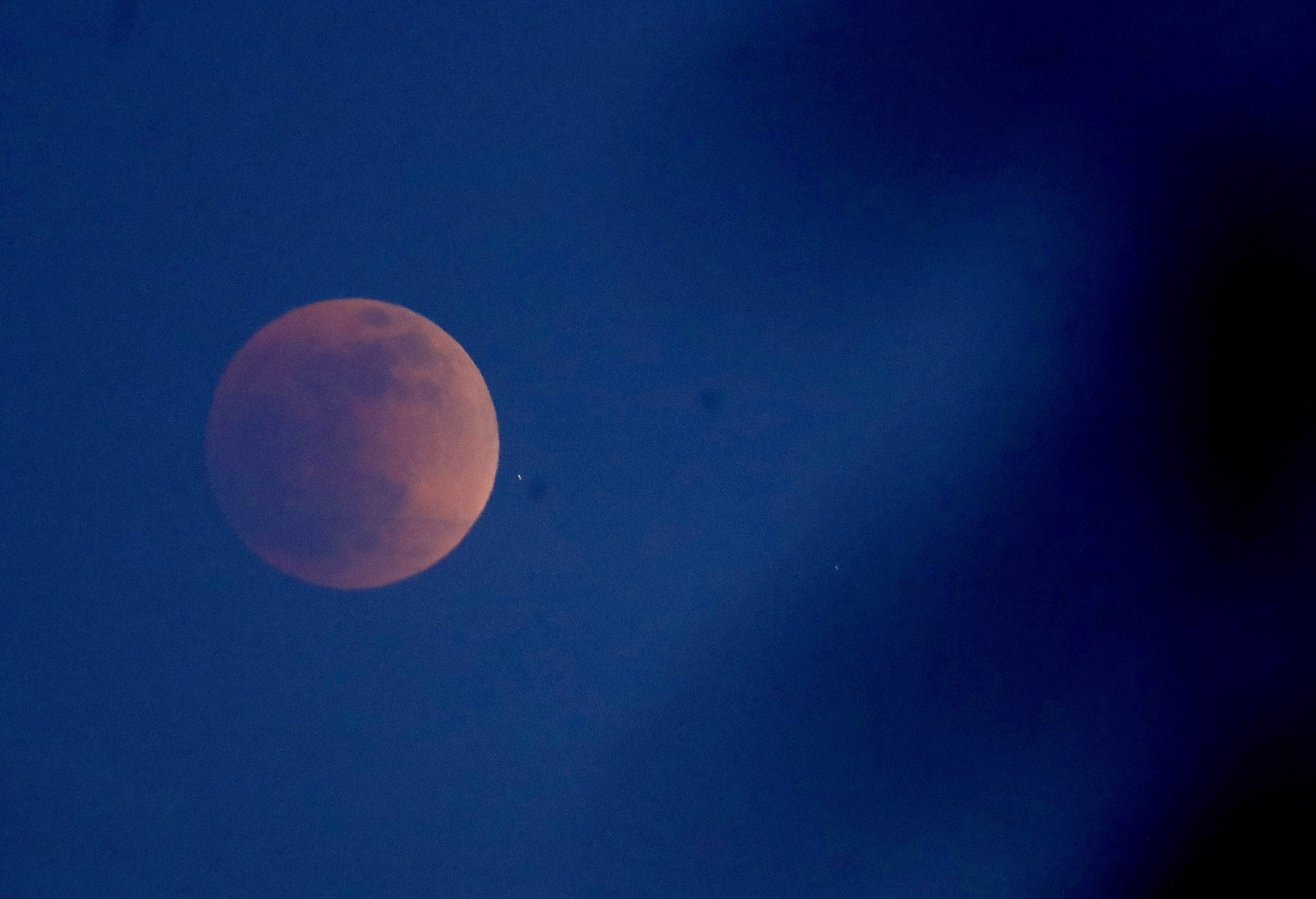The first blood moon of the year rises through the trees in the hills of Oakland, Calif., on Sunday, May 15, 2022. (Jane Tyska/Bay Area News Group)
