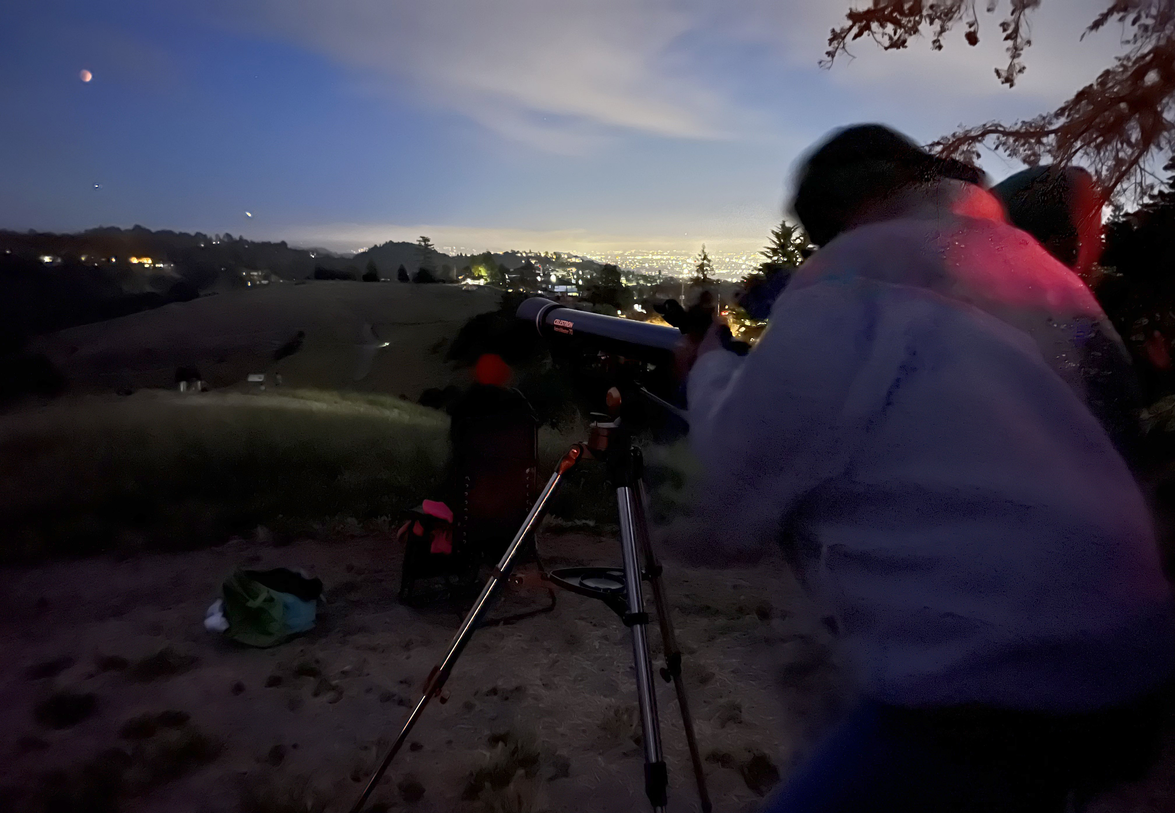 People gather to view a lunar eclipse of the first blood moon of the year in Oakland, Calif., on Sunday, May 15, 2022.