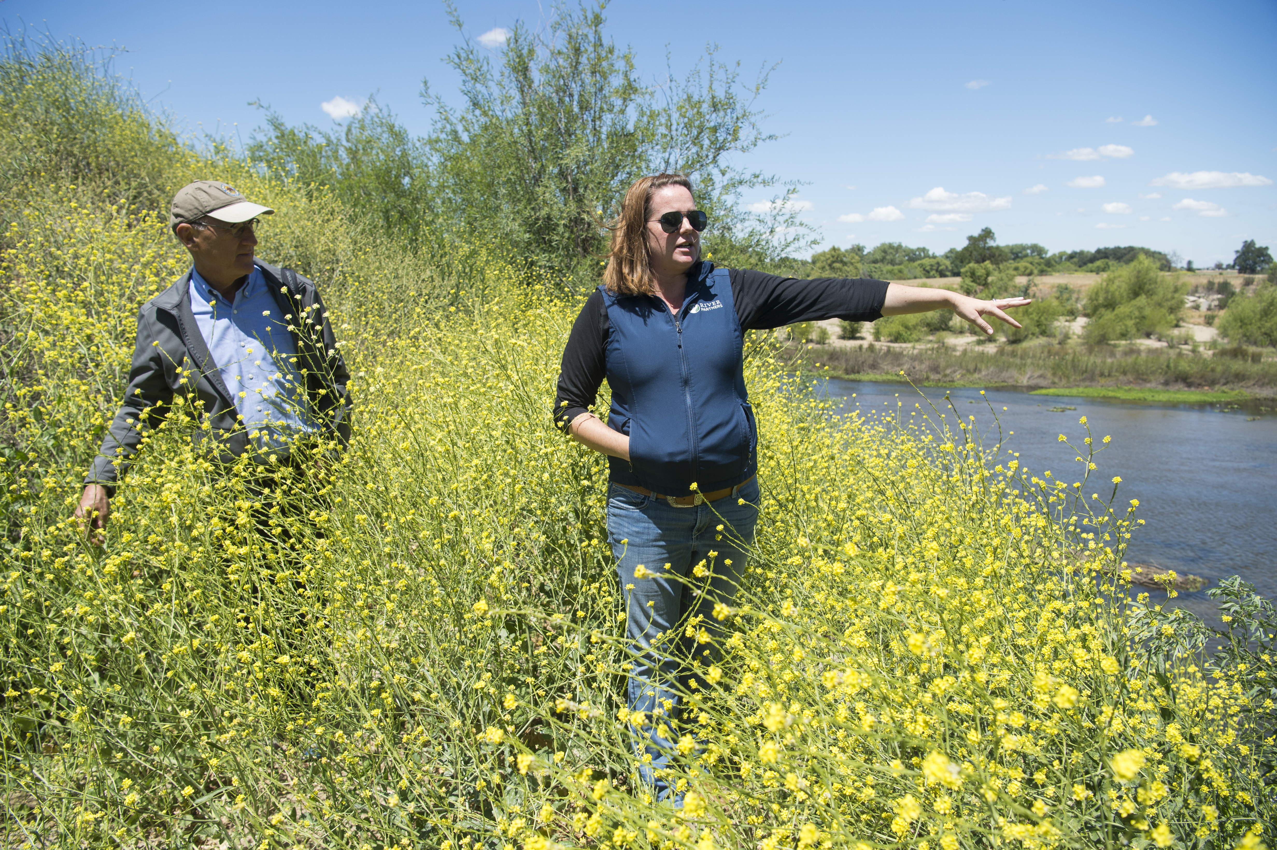 Julie Rentner, president of River Partners, right, and Armando Quintero, director for the California Department of Parks and Recreation, stand next to the Tuolumne river as Rentner talks at a new park location in Modesto, Calif.