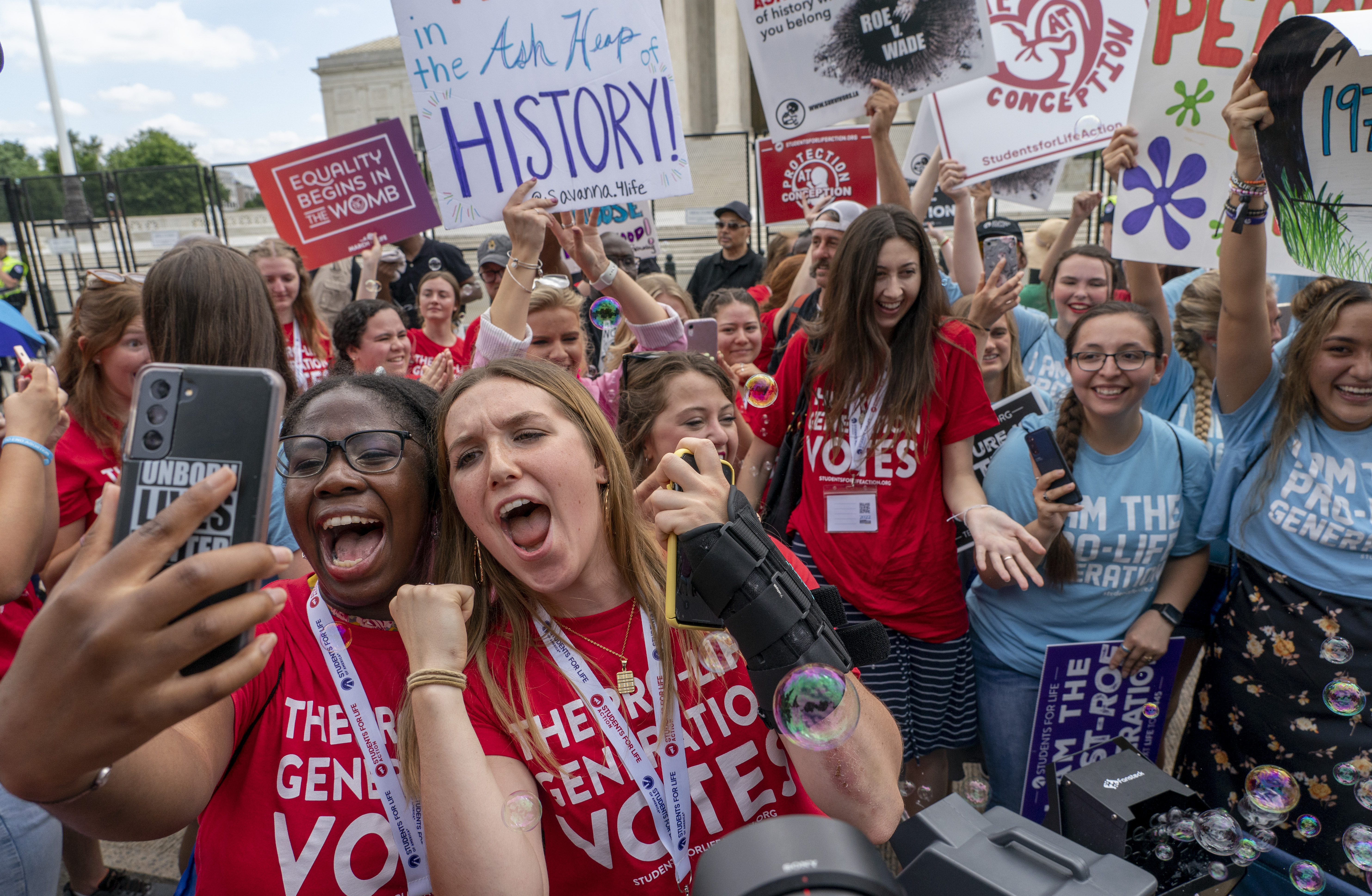 Anti-abortion protesters celebrate following Supreme Court's decision to overturn Roe v. Wade, federally protected right to abortion, in Washington, Friday, June 24, 2022. The Supreme Court has ended constitutional protections for abortion that had been in place nearly 50 years, a decision by its conservative majority to overturn the court's landmark abortion cases. (AP Photo/Gemunu Amarasinghe)